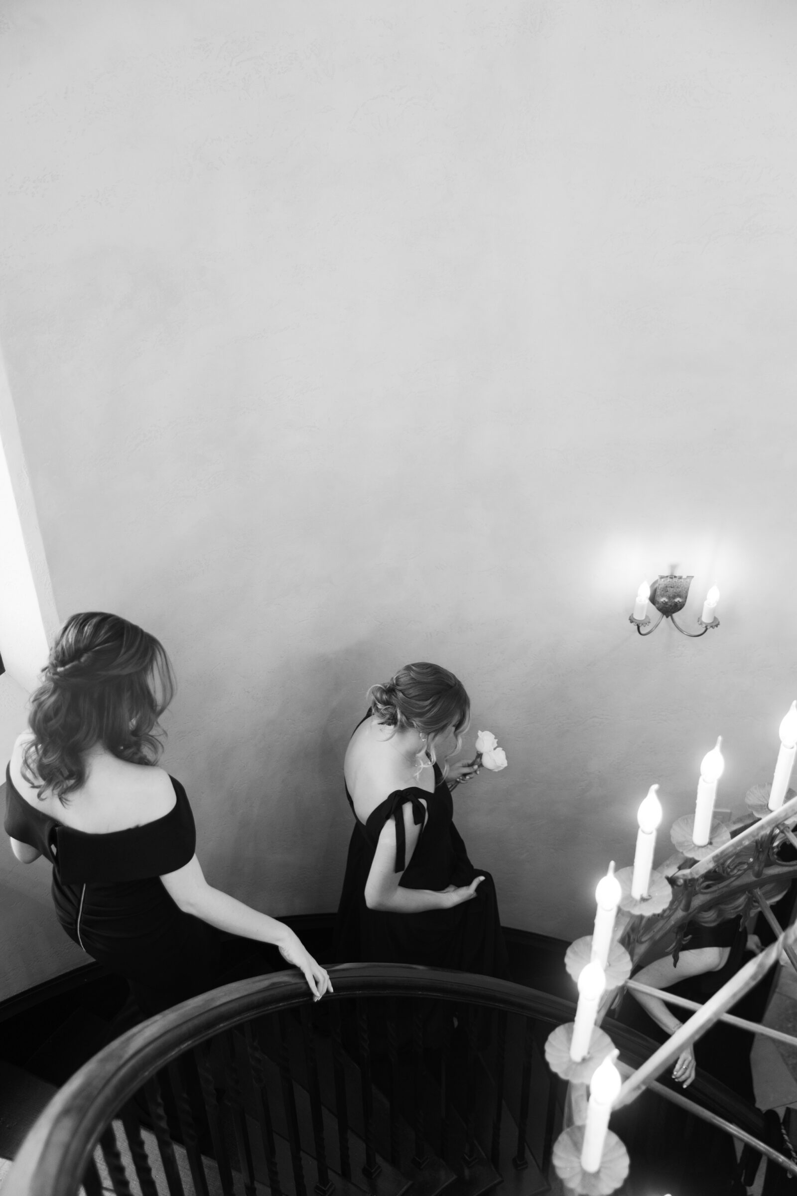 Dover Hall Estate Wedding in Manakin-Sabot, VA | RVA Wedding Photographer | black and white image of bridesmaids in black dresses descending a staircase before a Richmond, VA wedding ceremony at Dover Hall