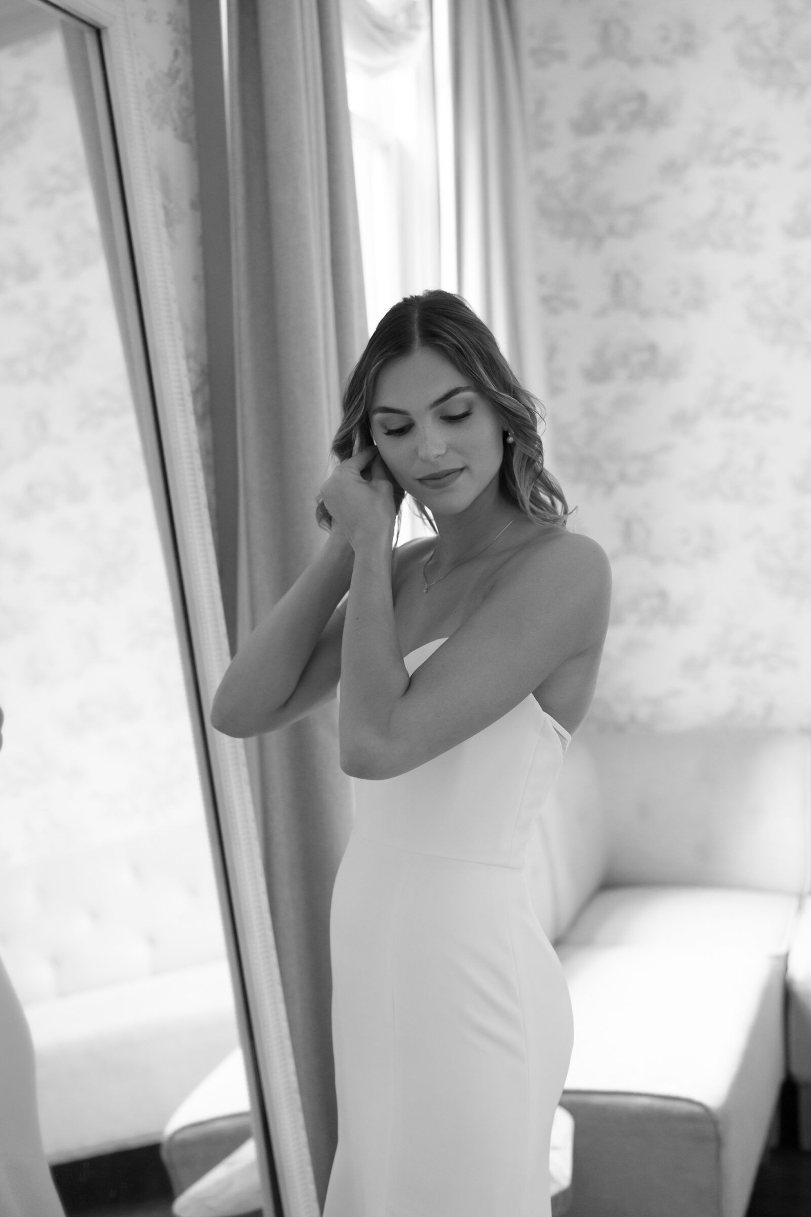 Rust Manor House Wedding in Leesburg, VA | Wedding Photographers in VA | black and white image of bride in bridal suite putting on earrings