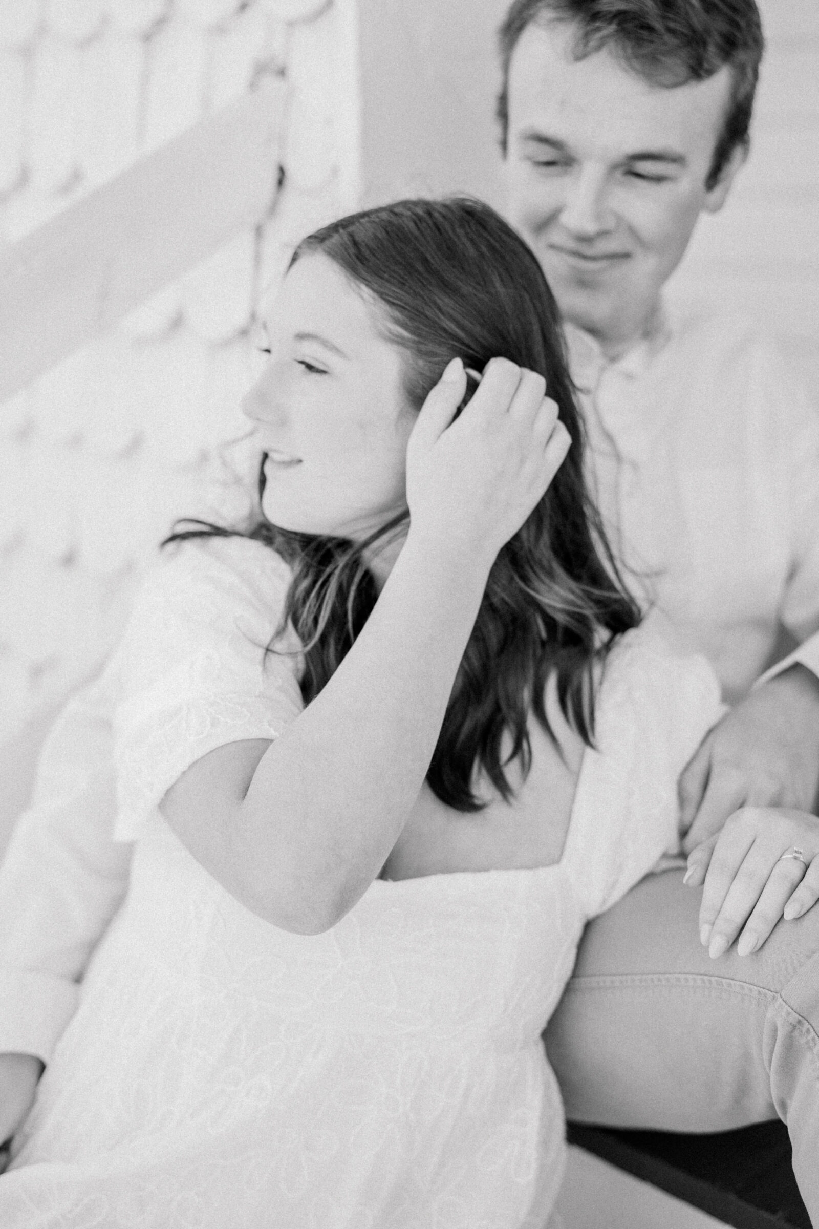 Engagement Session at VMFA in Richmond, VA | RVA Engagement Photographer | black and white image of girl sweeping hair out of face while sitting with fiancé at the Virginia Museum of Fine Arts in Richmond