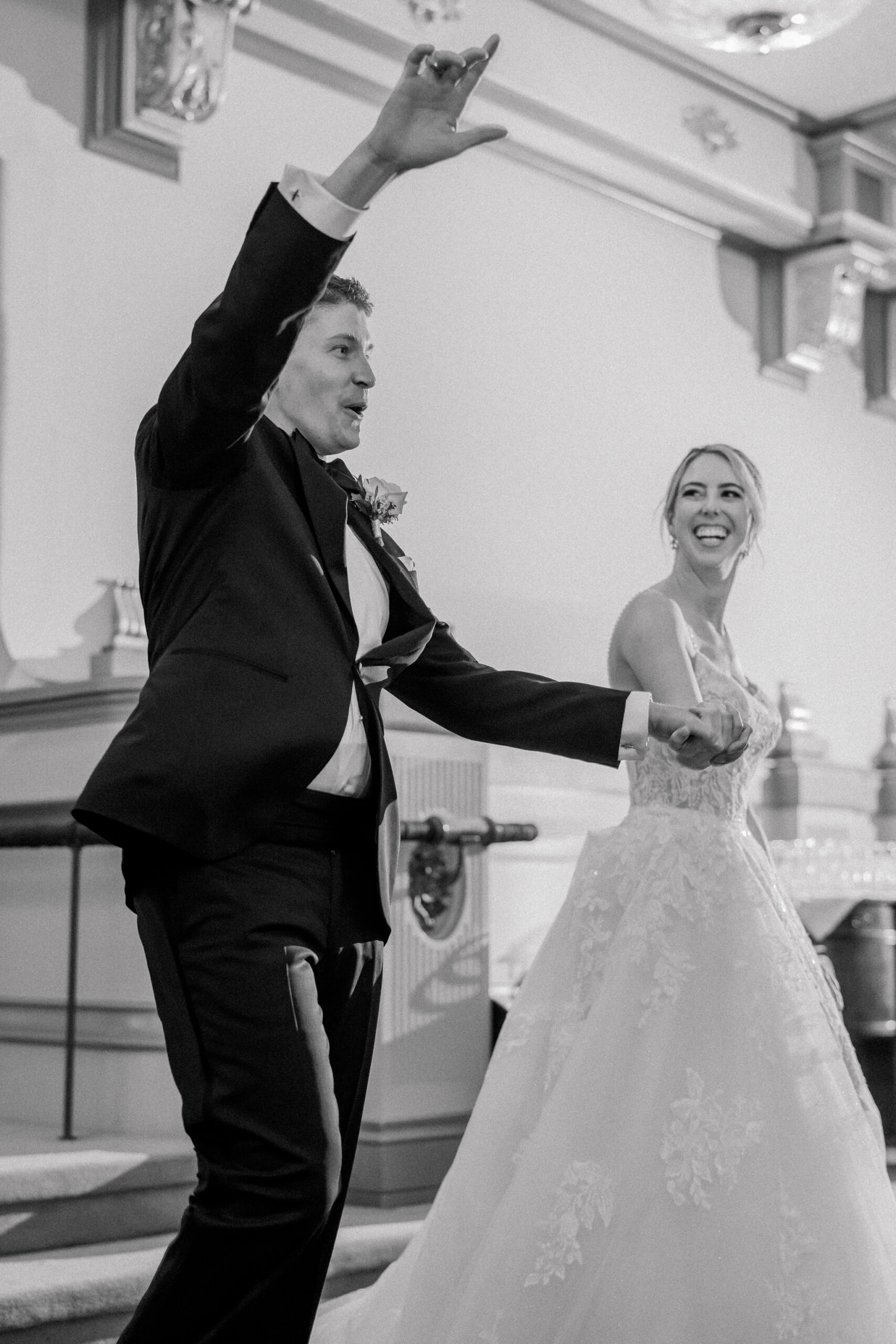 Hotel John Marshall Ballroom Wedding in Richmond, VA | Richmond Wedding Photographer | black and white image of bride and groom excitedly entering their reception at the John Marshall Hotel