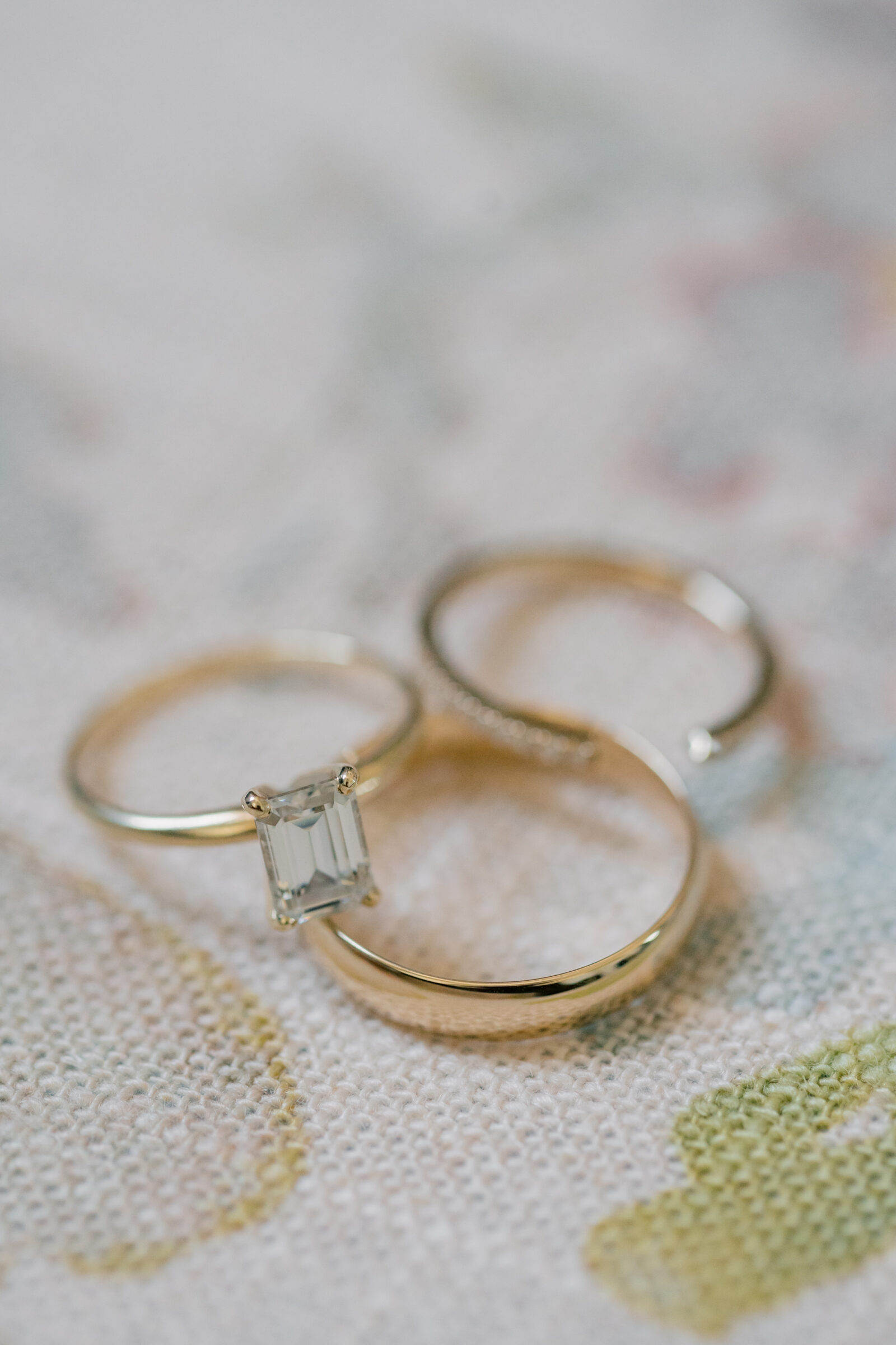 gold engagement and wedding rings on a floral background at Three Oaks Manor in VA