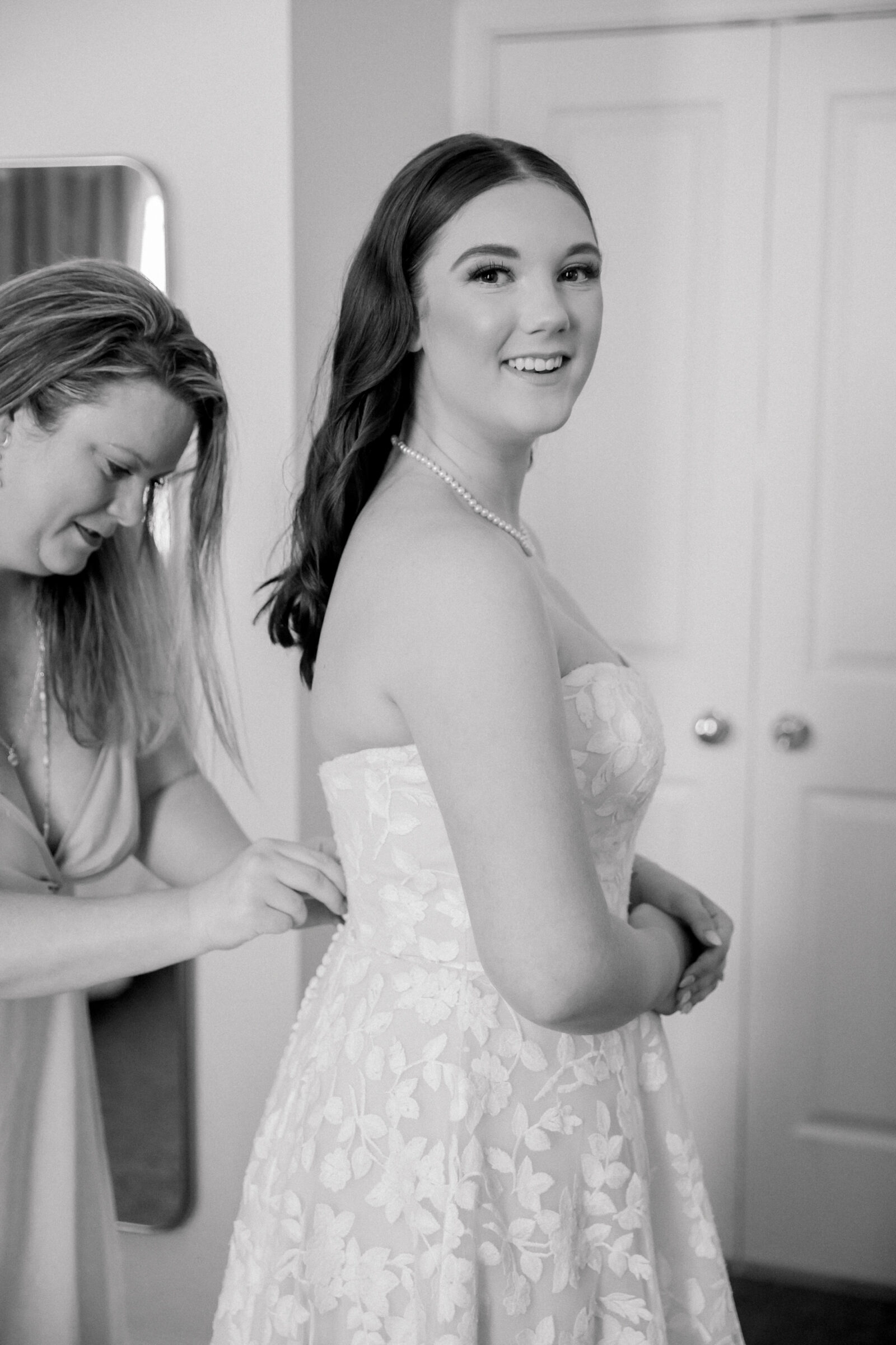 Lynchburg Virginia Wedding Photographer | black and white image of mother of the bride buttoning bride's floral wedding dress