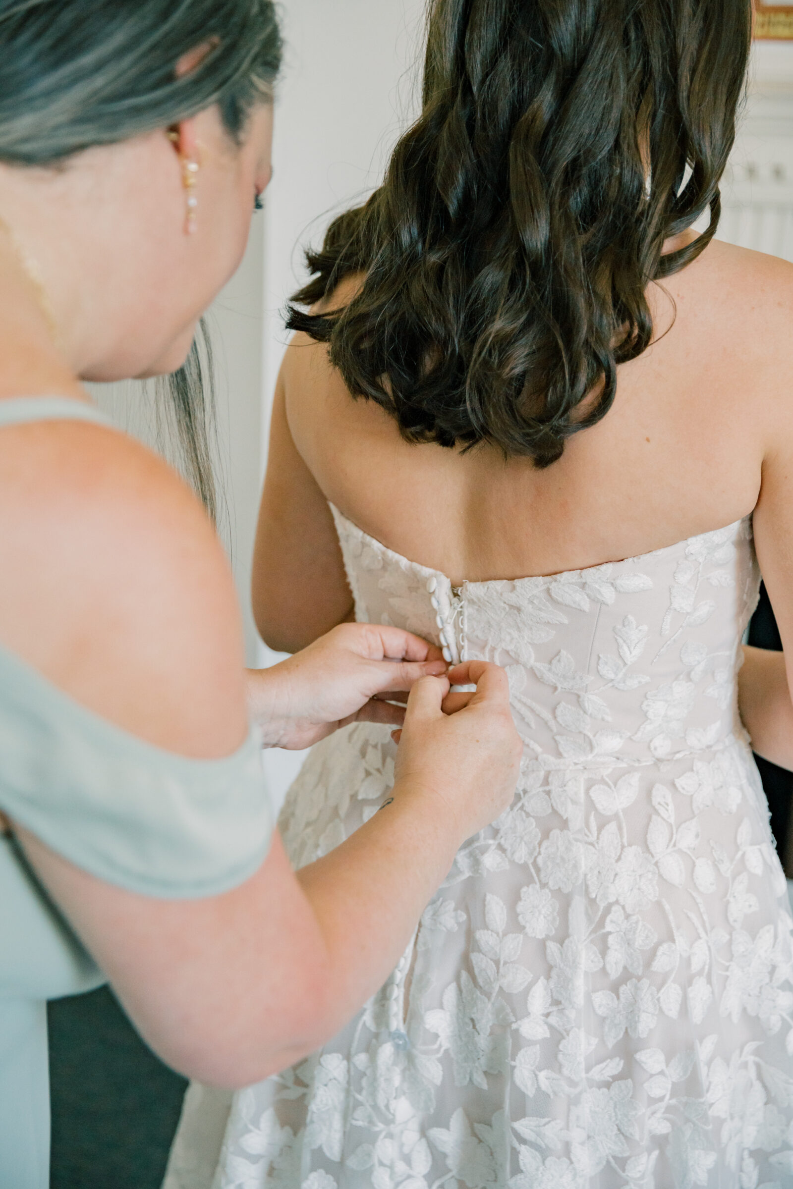 Lynchburg Virginia Wedding Photographer | bride in floral wedding gown gets her dress buttoned