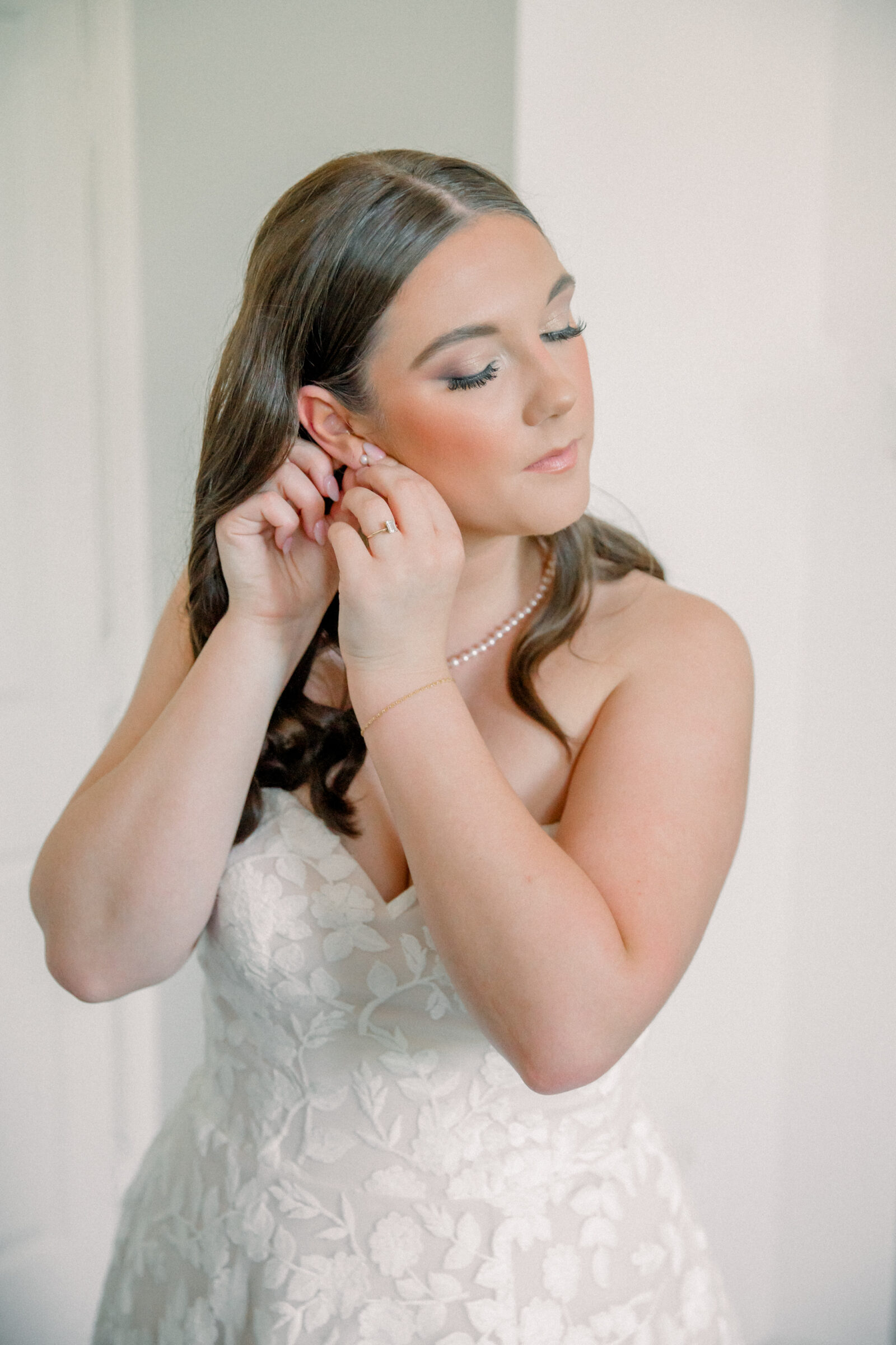 Lynchburg Virginia Wedding Photographer | bride in white floral wedding dress adjusts her earrings before her Three Oaks Manor wedding ceremony