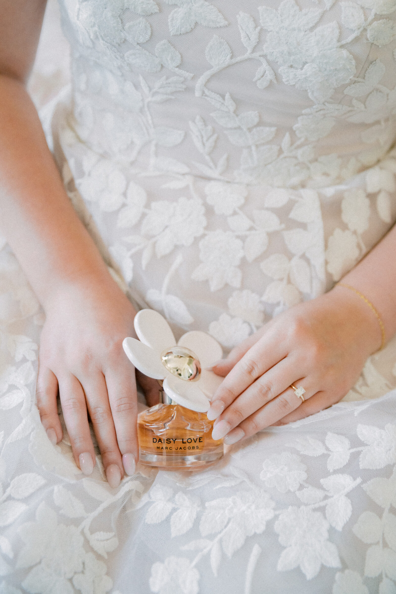 Lynchburg Virginia Wedding Photographer | bride in white floral gown holds a bottle of Daisy by Marc Jacobs perfume