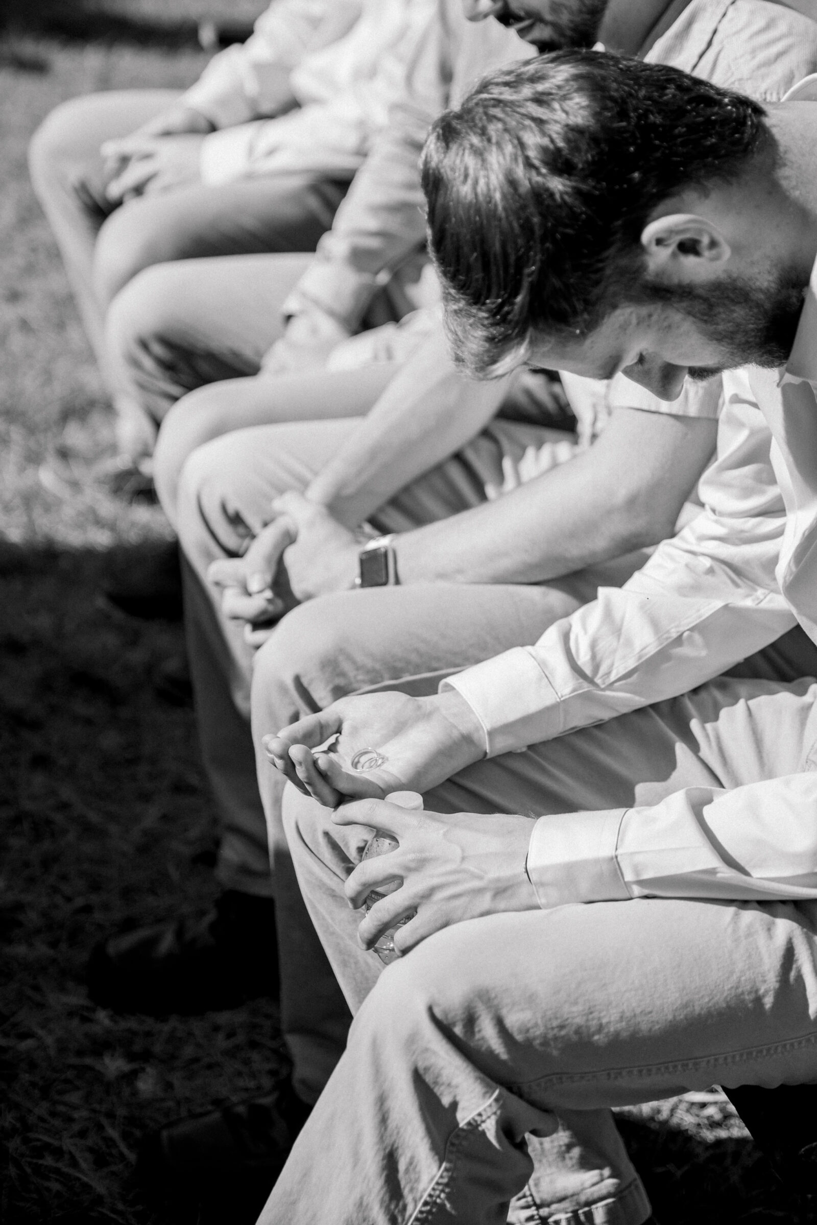 Three Oaks Manor Wedding in Madison Heights, VA | Virginia Wedding Photographer | black and white image of guests praying over wedding bands during a wedding ceremony