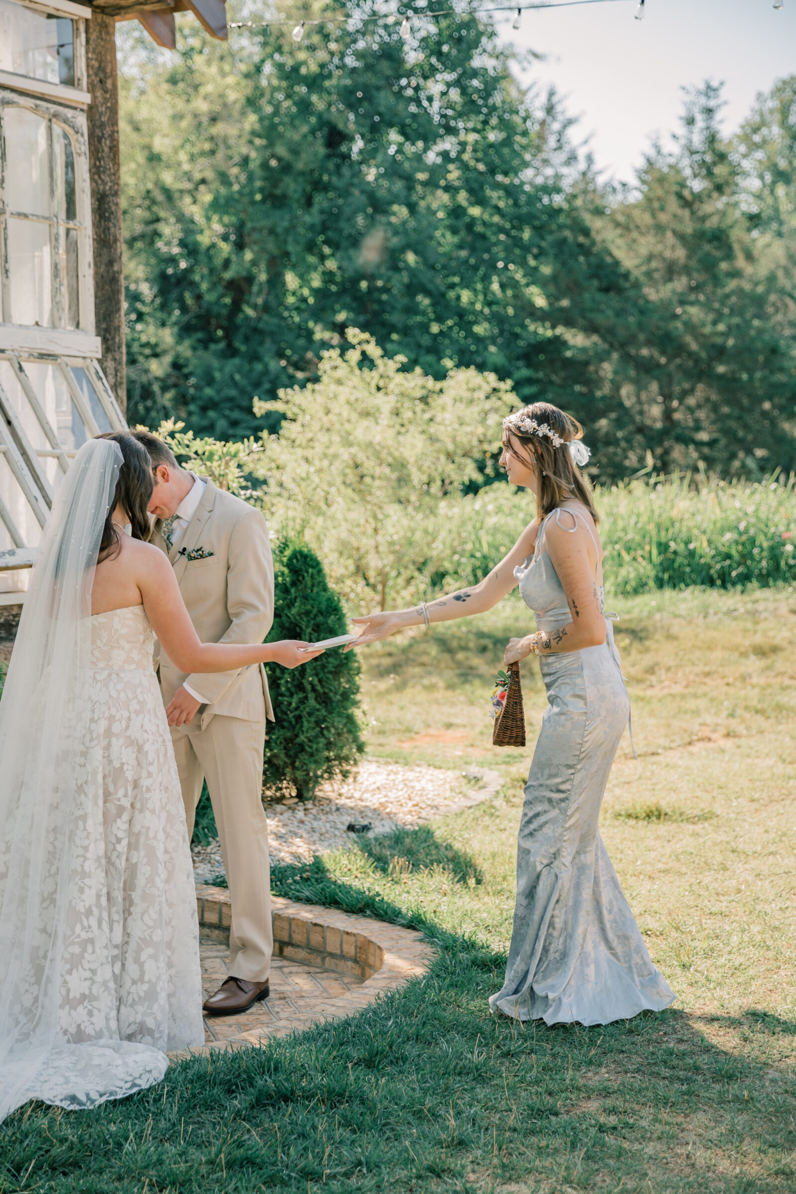 Three Oaks Manor Wedding in Madison Heights, VA | Virginia Wedding Photographer | sister of the bride hands vow book to bride during wedding ceremony