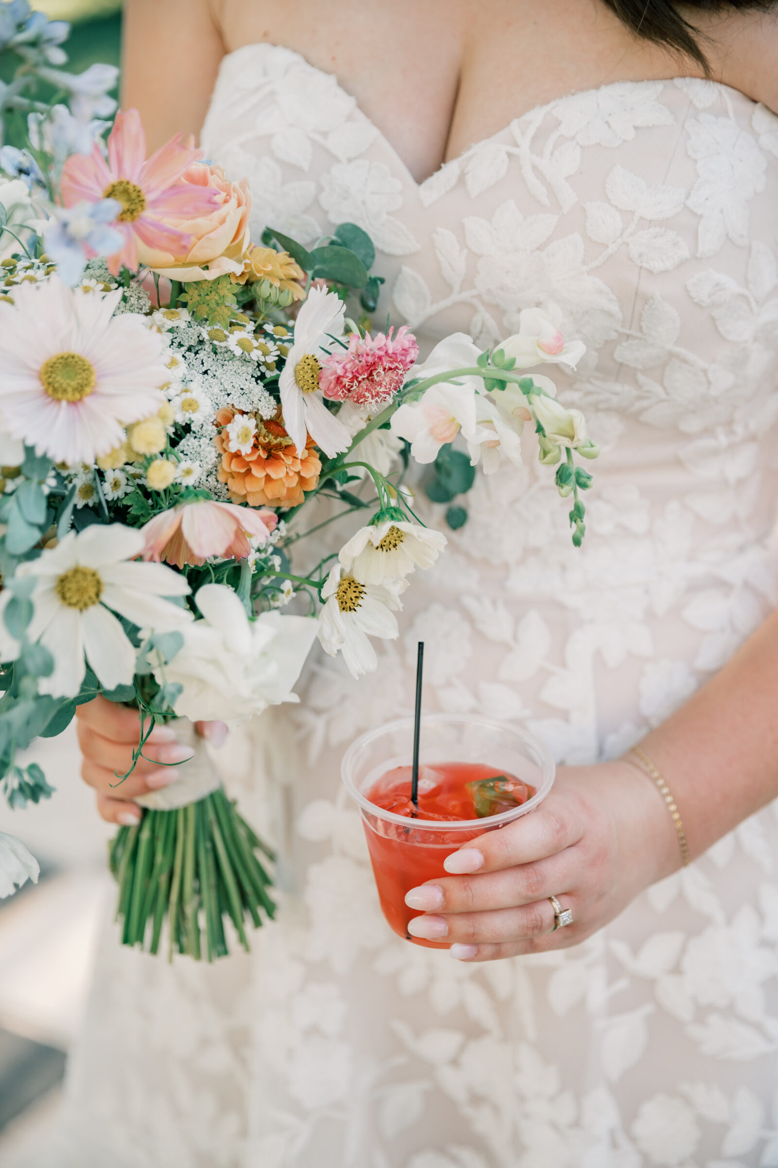 Three Oaks Manor Wedding in Madison Heights, VA | Virginia Wedding Photographer | closeup image of bride holding colorful wildflower bridal bouquet and signature cocktail