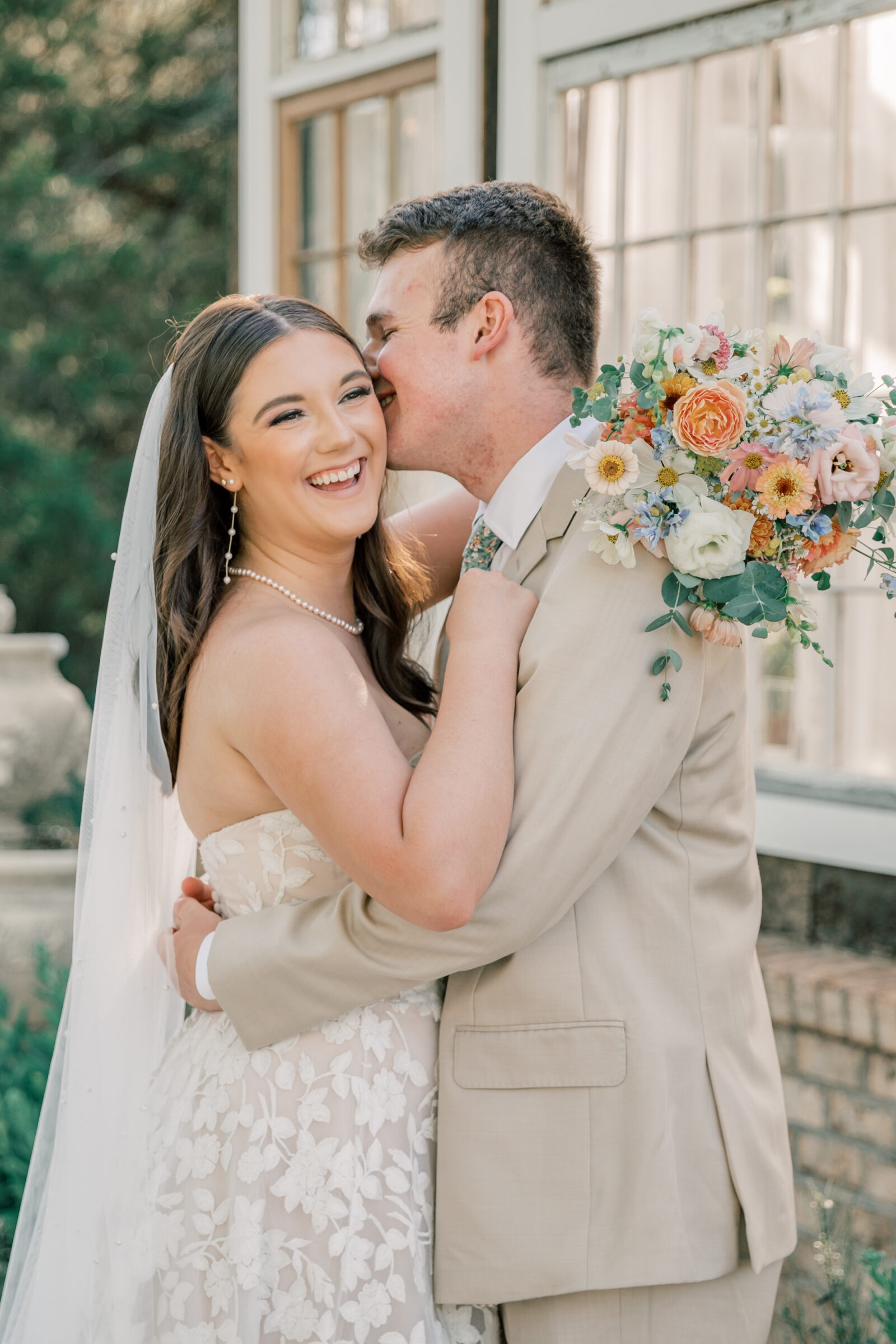 Three Oaks Manor Wedding in Madison Heights, VA | Virginia Wedding Photographer | groom in tan suit gives his bride a kiss on the cheek