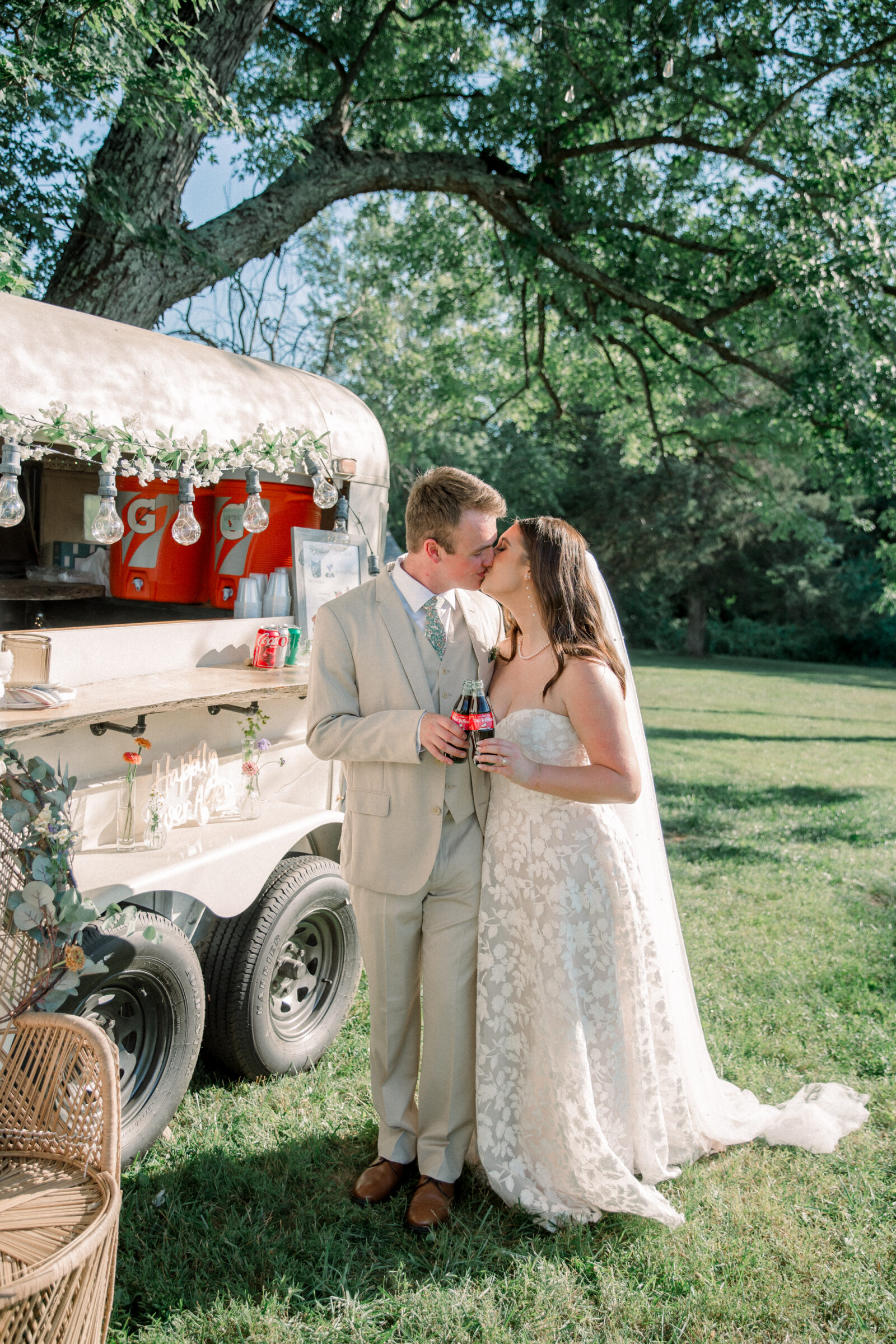 Three Oaks Manor Wedding in Madison Heights, VA | Virginia Wedding Photographer | bride and groom share a kiss standing outside of their mobile bar while holding custom Coca-Cola bottles