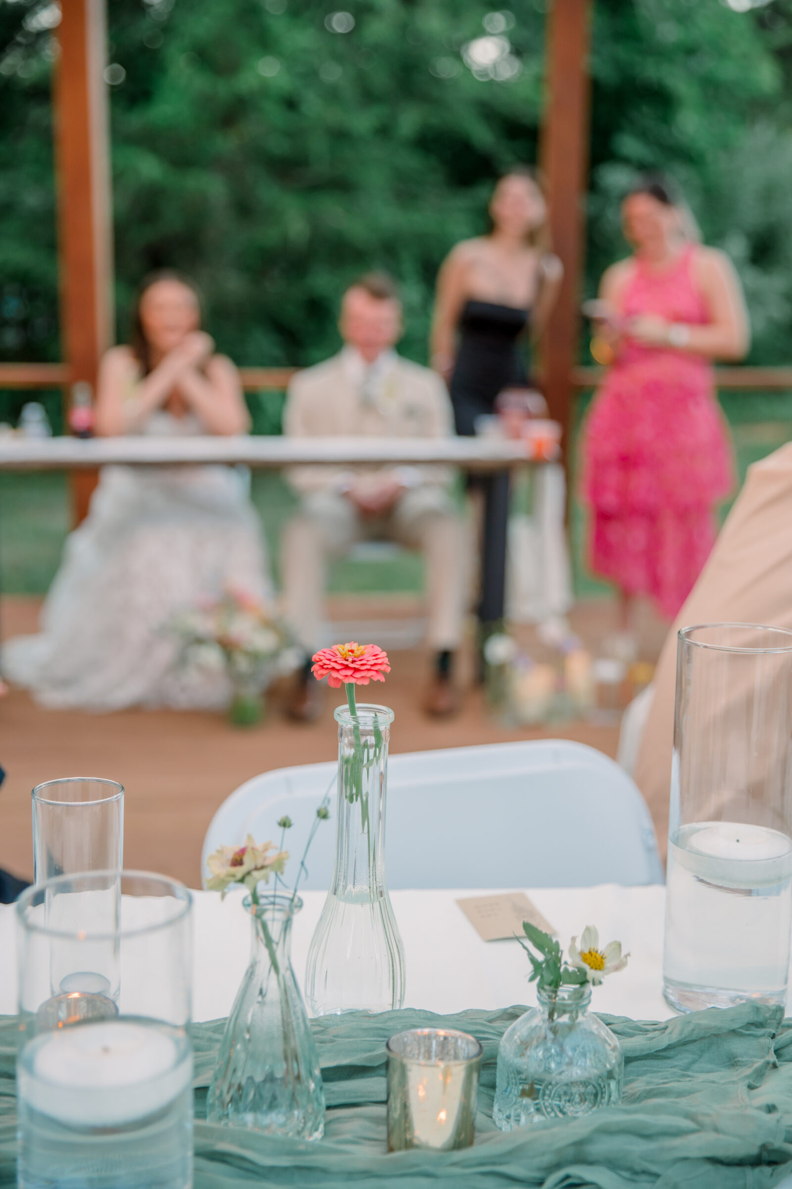 Three Oaks Manor Wedding in Madison Heights, VA | Virginia Wedding Photographer | flower in bud vase with reception toasts happening in the background