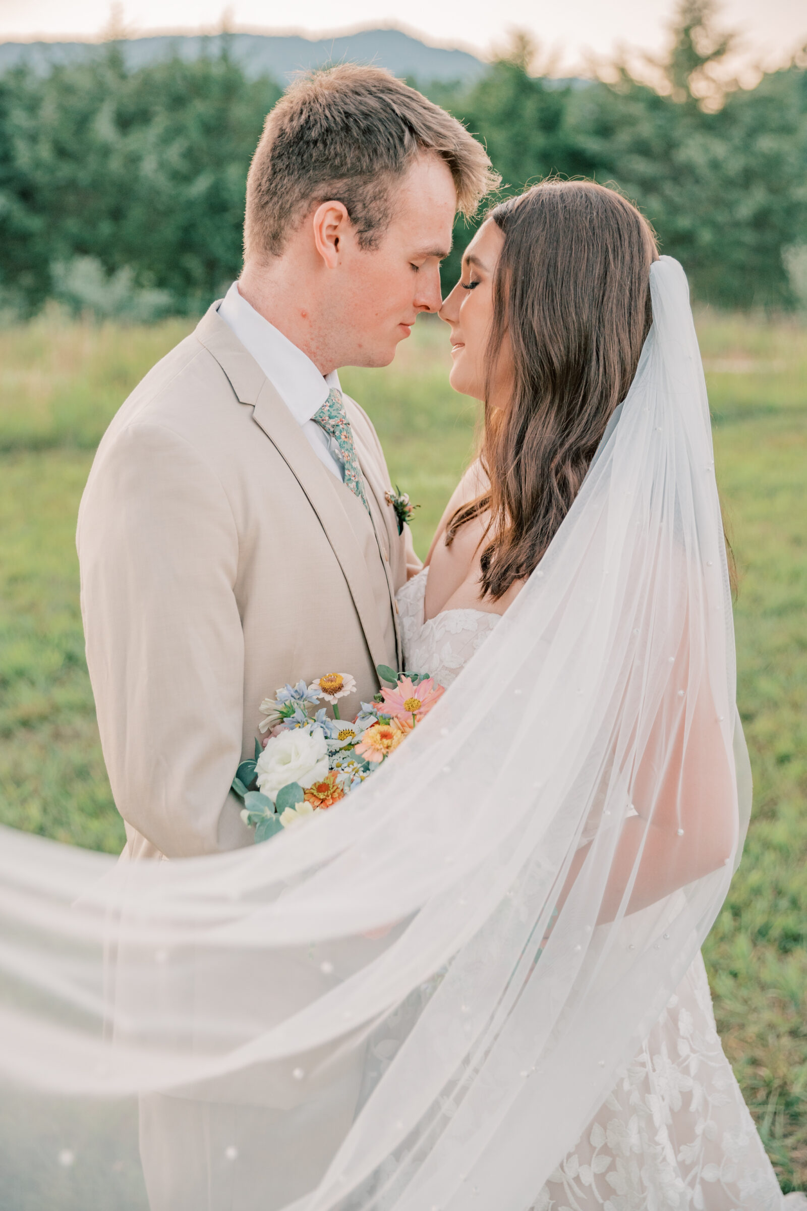 Three Oaks Manor Wedding in Madison Heights, VA | Virginia Wedding Photographer | bride and groom about to kiss with white tulle and pearl veil blowing gently in the breeze