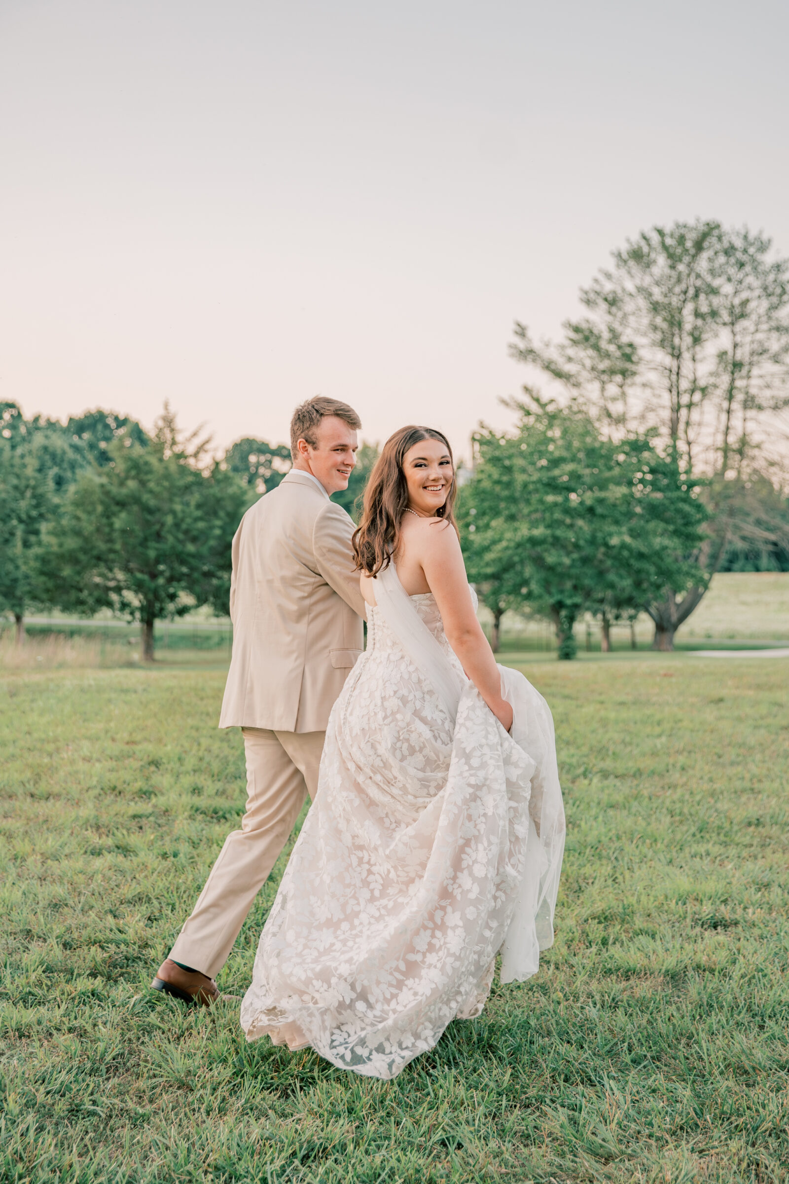 Three Oaks Manor Wedding in Madison Heights, VA | Virginia Wedding Photographer | bride and groom look over their shoulders toward the camera as they walk into the sunset