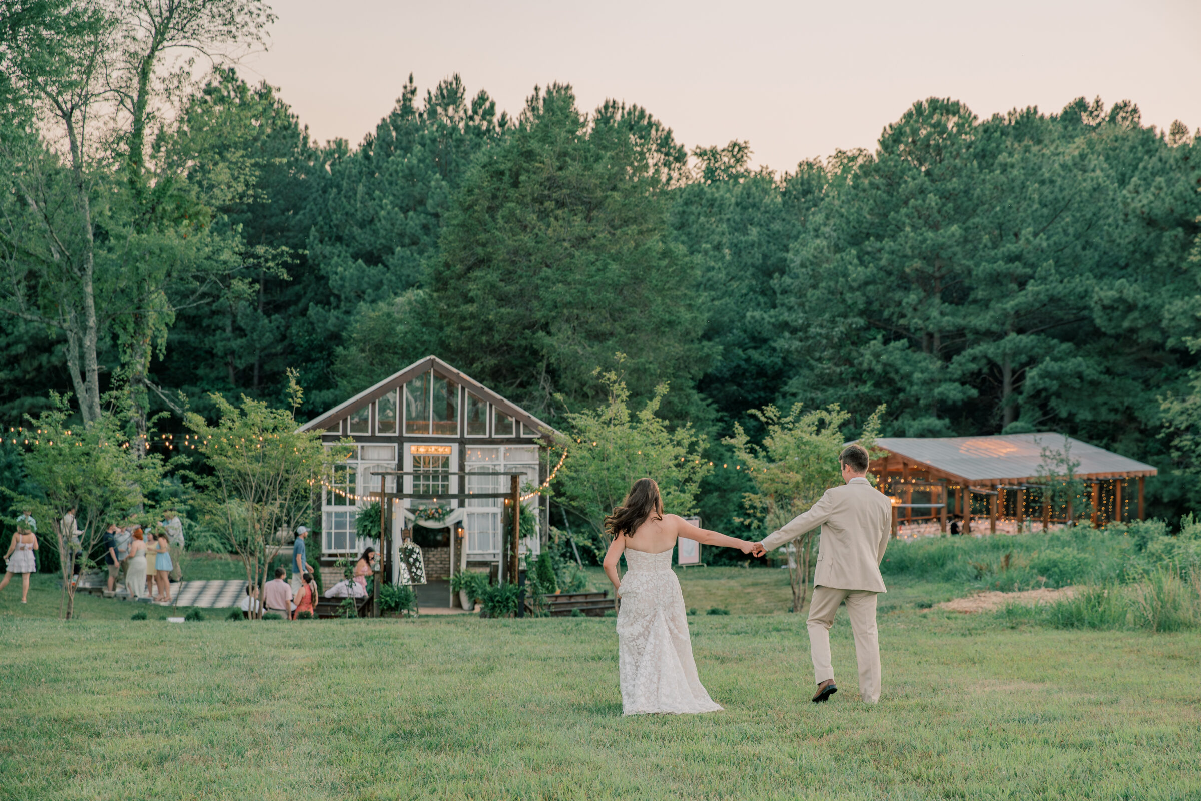 Three Oaks Manor Wedding in Madison Heights, VA | Virginia Wedding Photographer | bride and groom walk hand in hand towards their venue after slipping away from their reception for sunset pictures