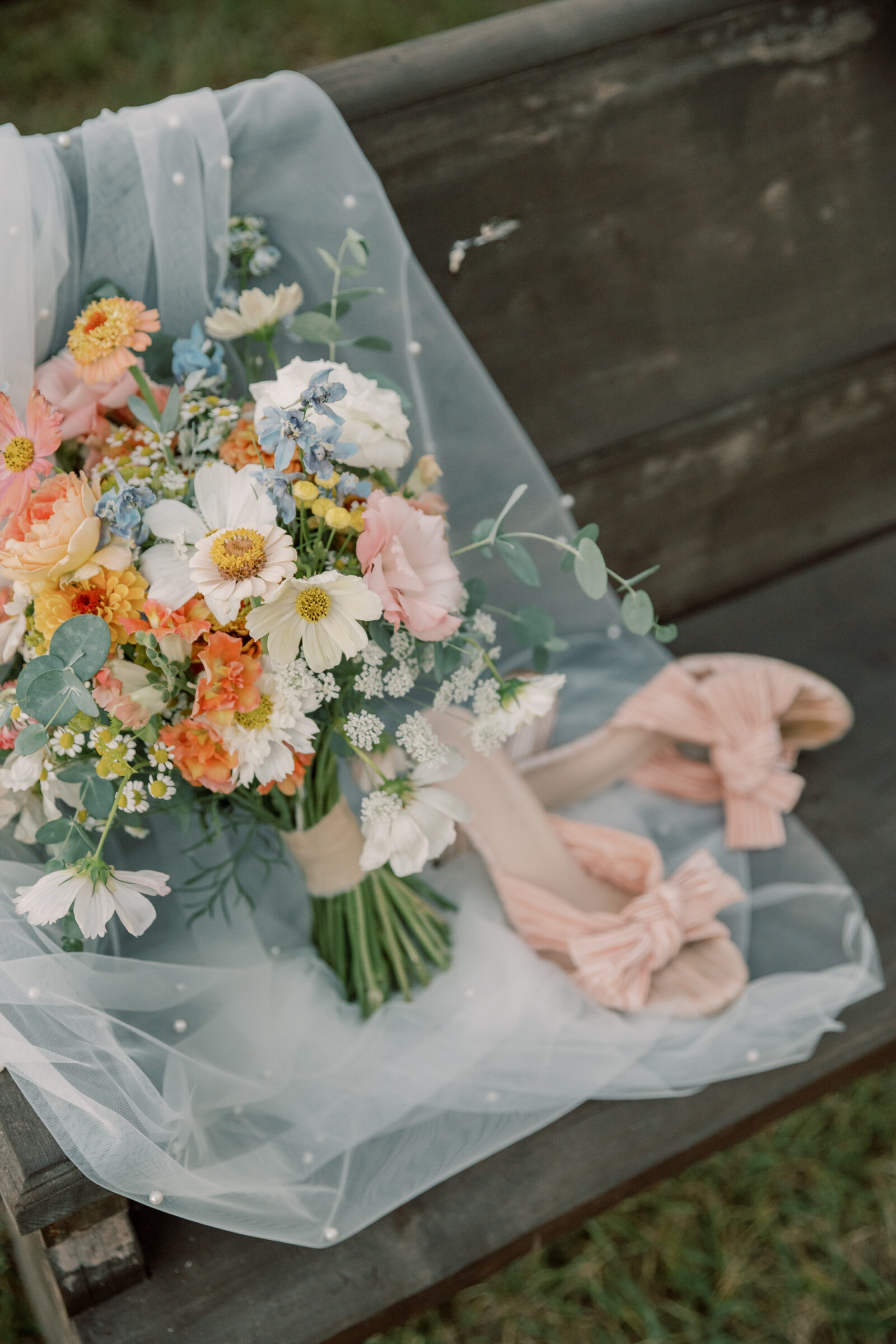 Three Oaks Manor Wedding in Madison Heights, VA | Virginia Wedding Photographer | bridal bouquet and pink heels sitting on top of a white pearl veil that draped over a wooden pew