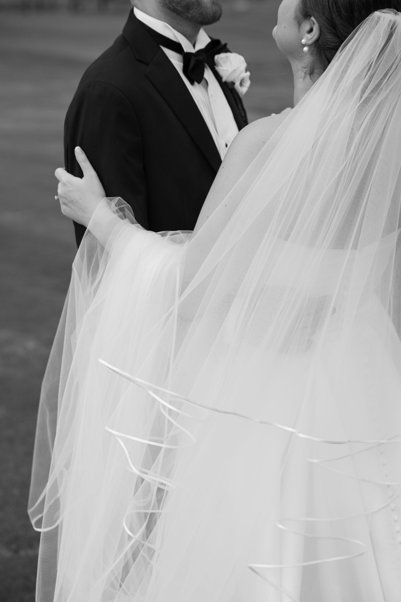 Willow Oaks Country Club Wedding in Richmond, VA | Country Club Venues in Richmond | black and white image of bride and groom sharing a soft embrace with veil gently blowing in the wind