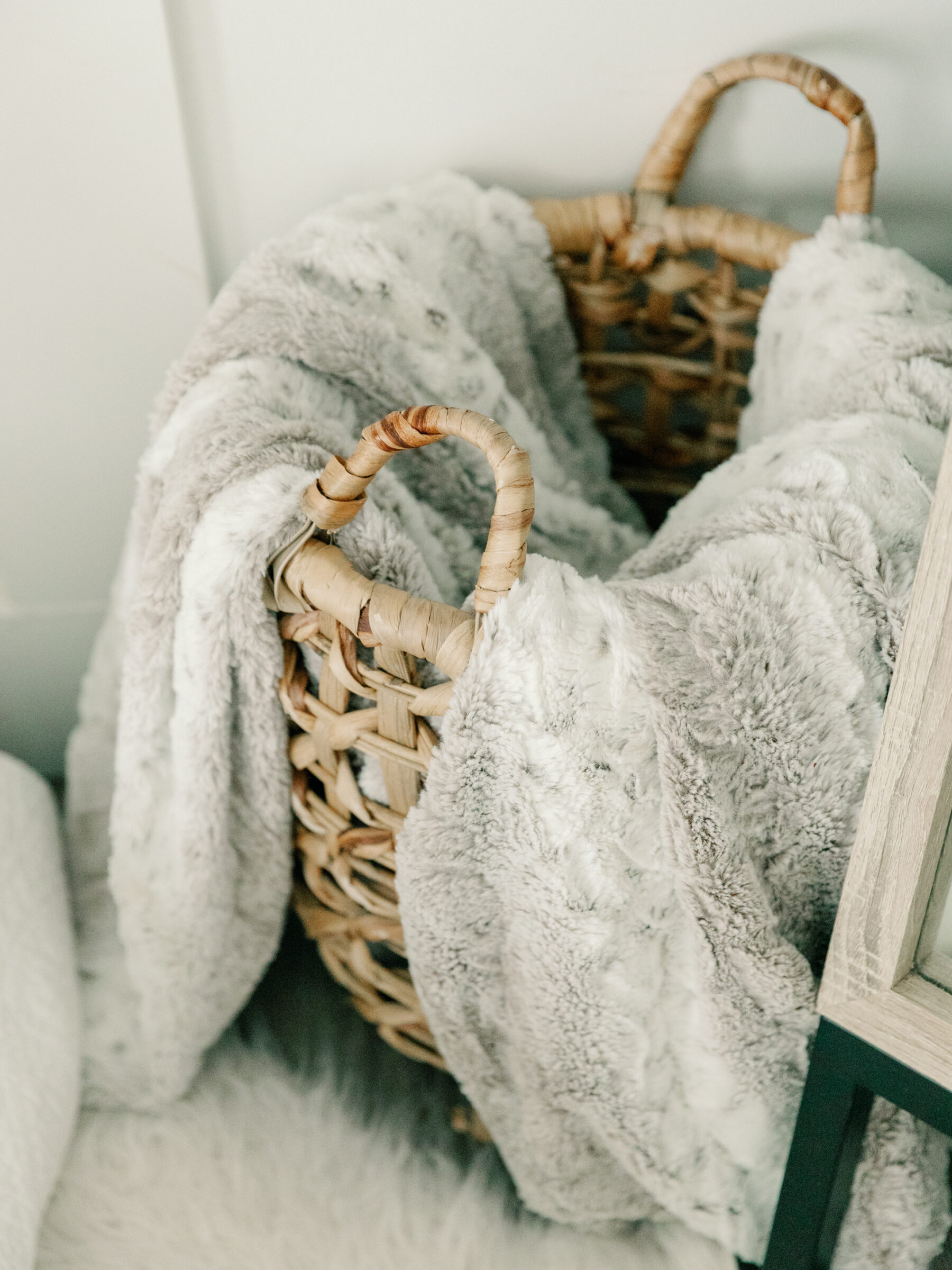 A woven basket filled with soft, gray blankets at Carbone Studios, adding warmth and comfort to the serene boudoir photography space in Ashland, VA.