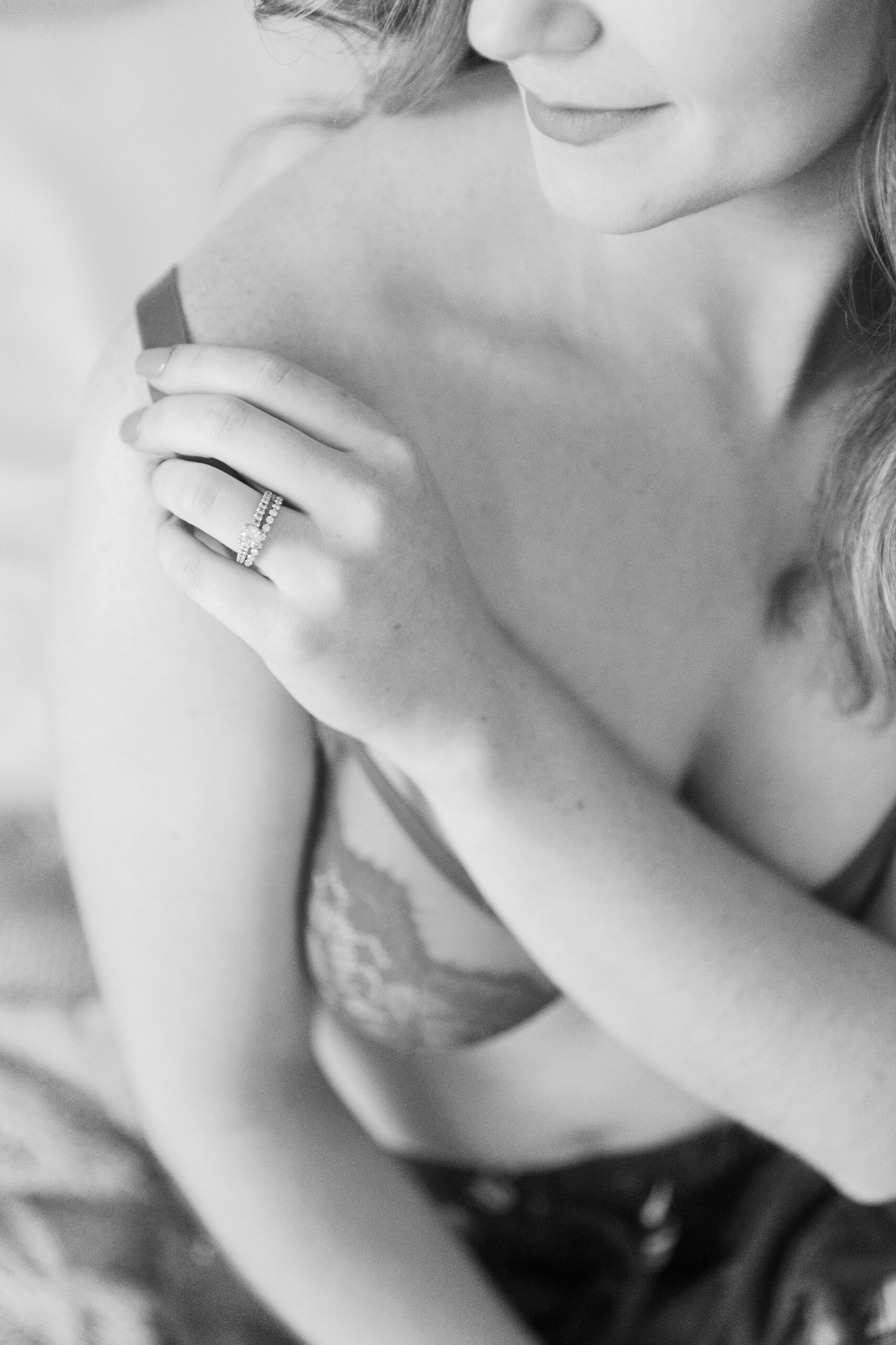 Winter Boudoir in Richmond VA | black & white closeup image of girl with an engagement ring touching her bra strap