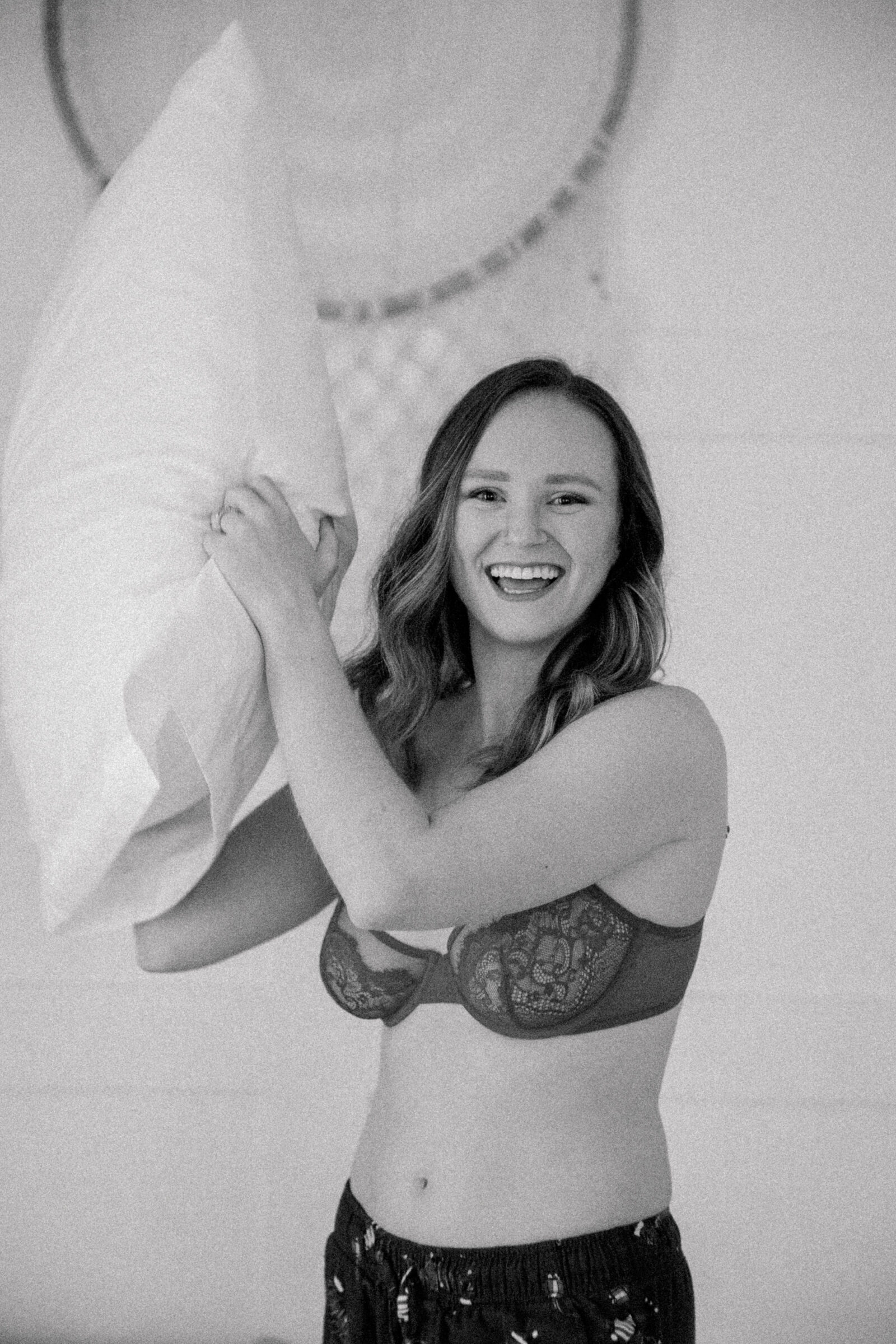 Holiday Boudoir in Richmond | black and white image of girl in lingerie and pajama bottoms in a pillow fight