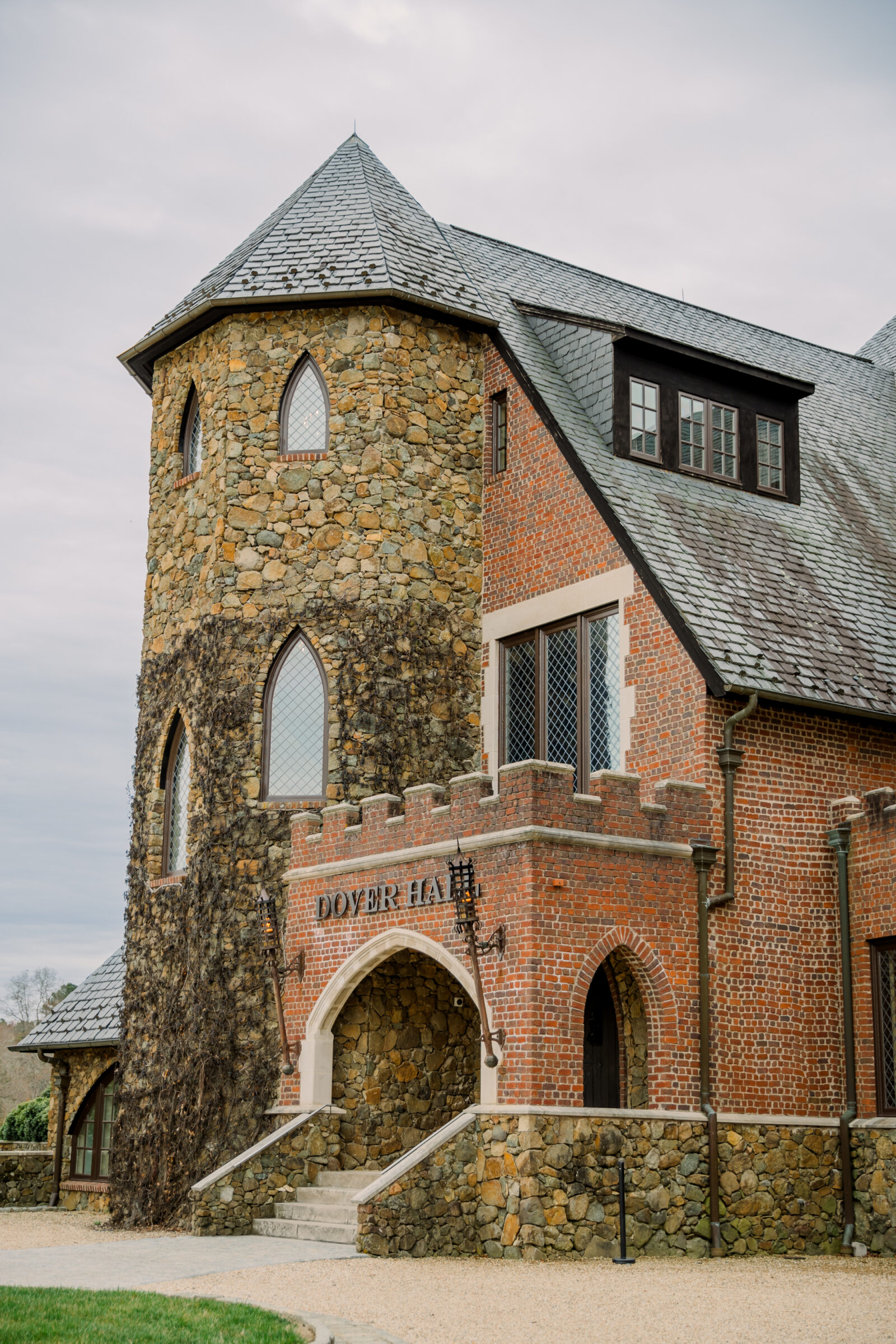 A close-up of the grand entrance of Dover Hall in Richmond, VA, featuring its stone and brick exterior, arched doorway, and the elegant "Dover Hall" sign, perfect for a majestic wedding celebration.
