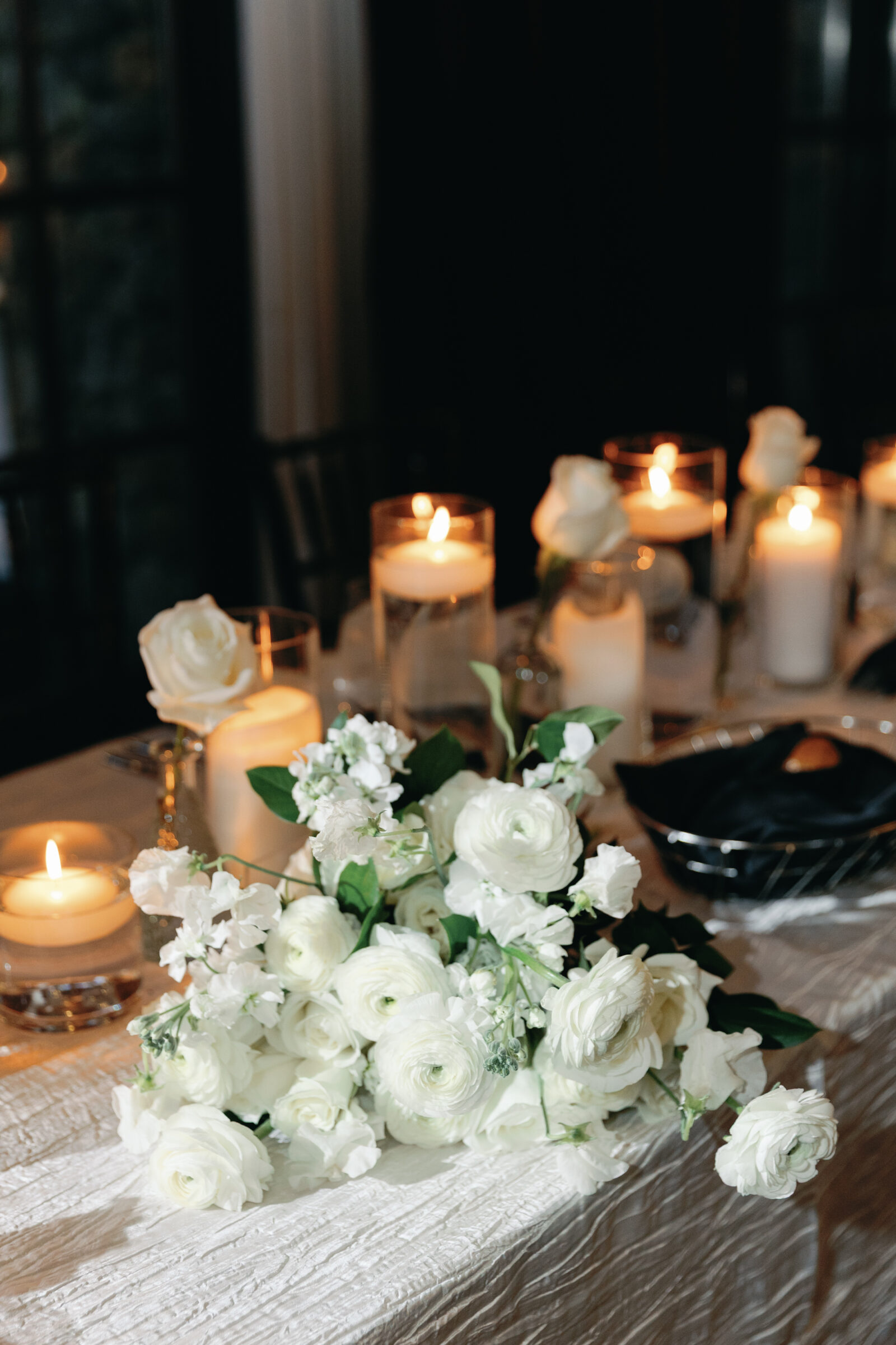 A beautifully arranged table at a Dover Hall wedding reception in Richmond VA, featuring white flowers and glowing candles that create a romantic and elegant atmosphere.