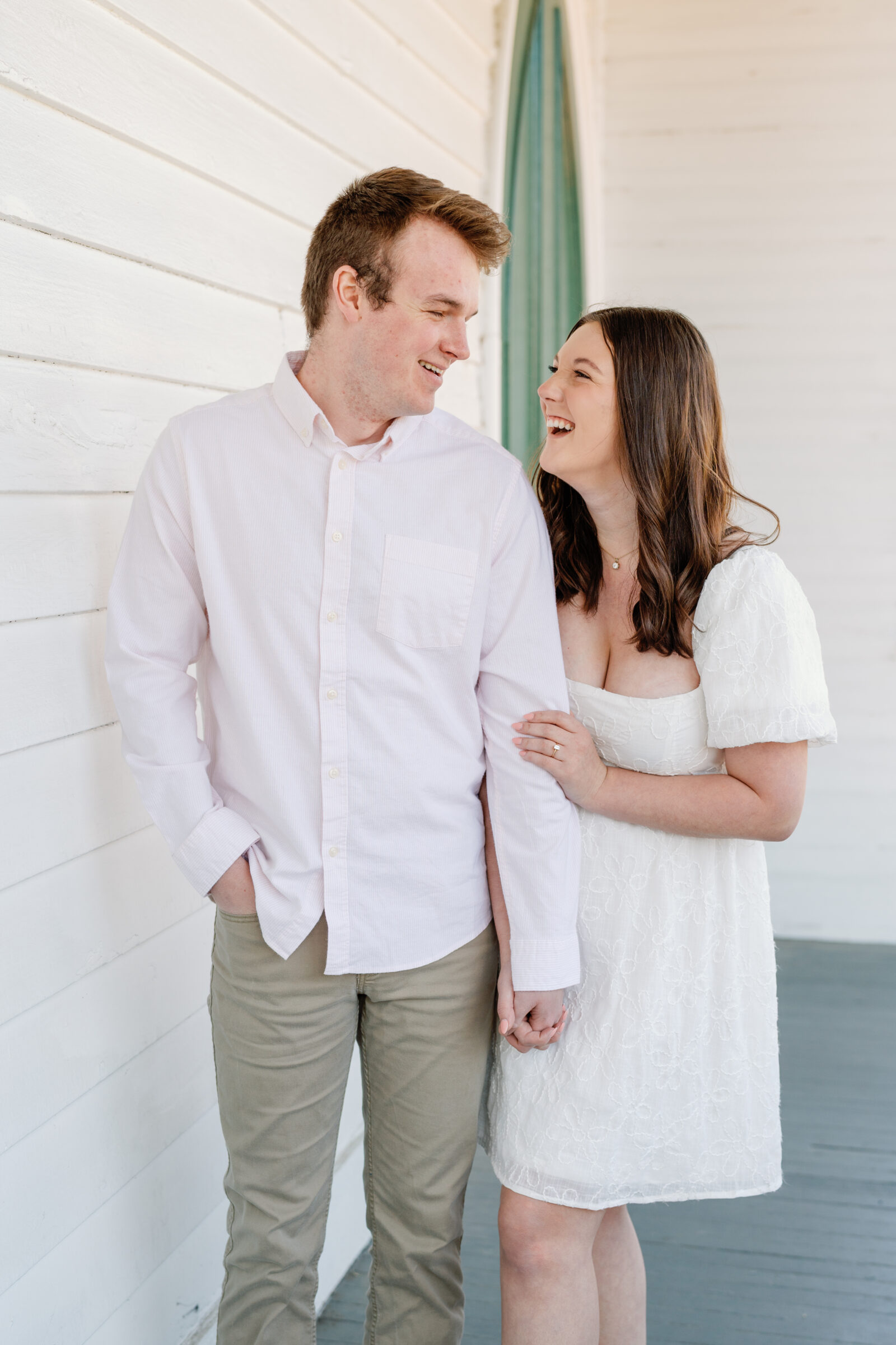 Engagement Session at the VMFA in Richmond VA | couple laugh with each other in front of a white wall