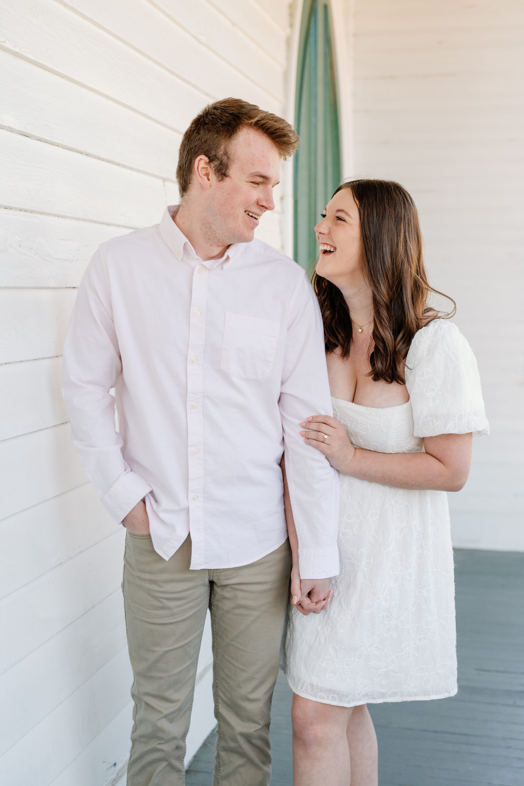 Engagement Session at the VMFA in Richmond VA | couple laugh with each other in front of a white wall