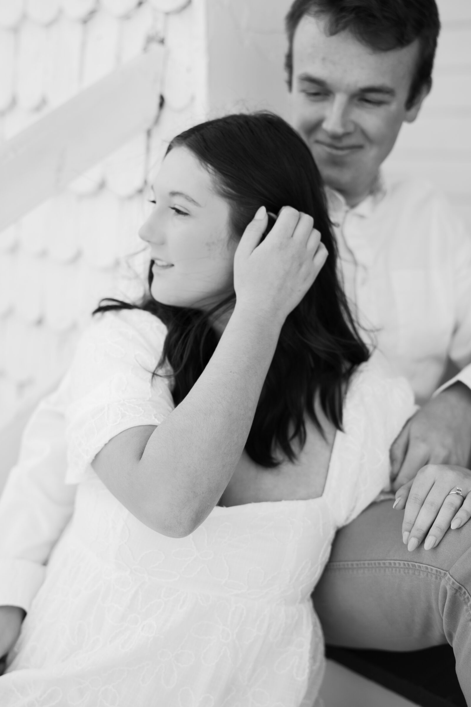Engagement Session at the VMFA in Richmond VA | black and white image of a girl pushing her hair behind her ear as she sits on a step with her fiance.