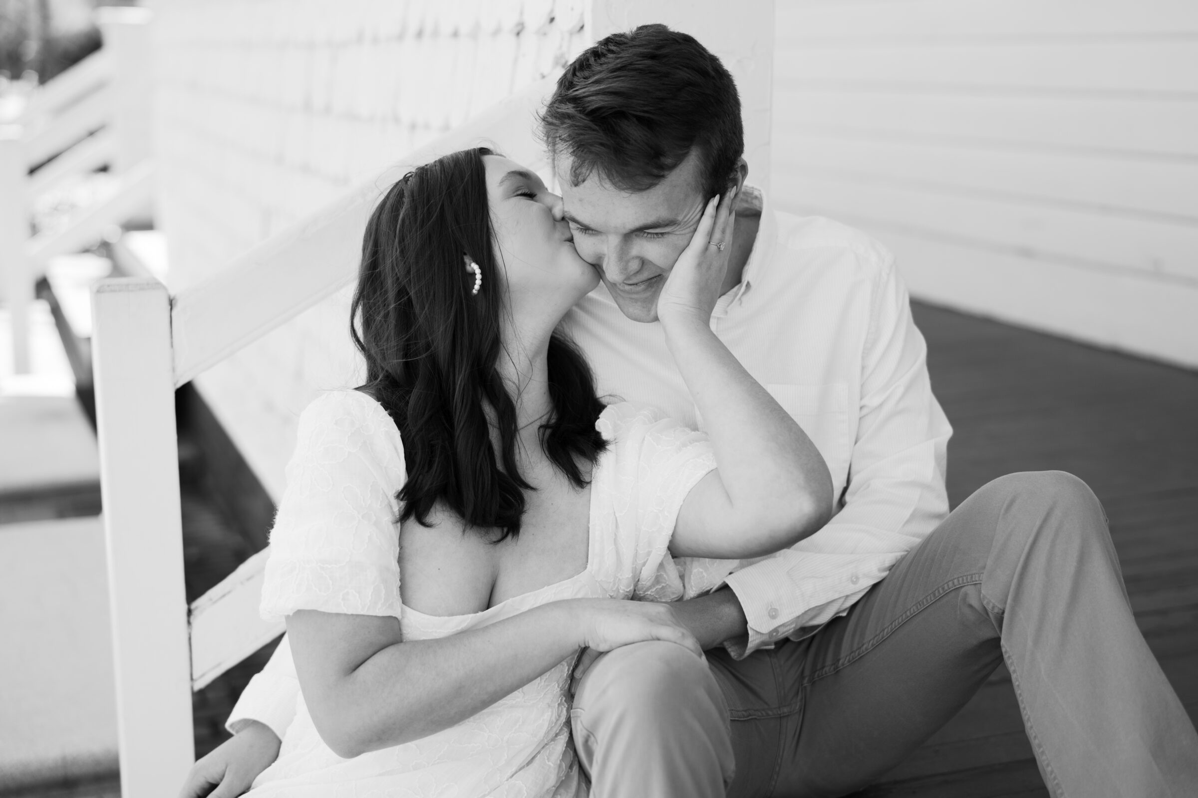 Engagement Session at the VMFA in Richmond VA | black and white image of girl kissing her fiance's cheek as they sit on some steps