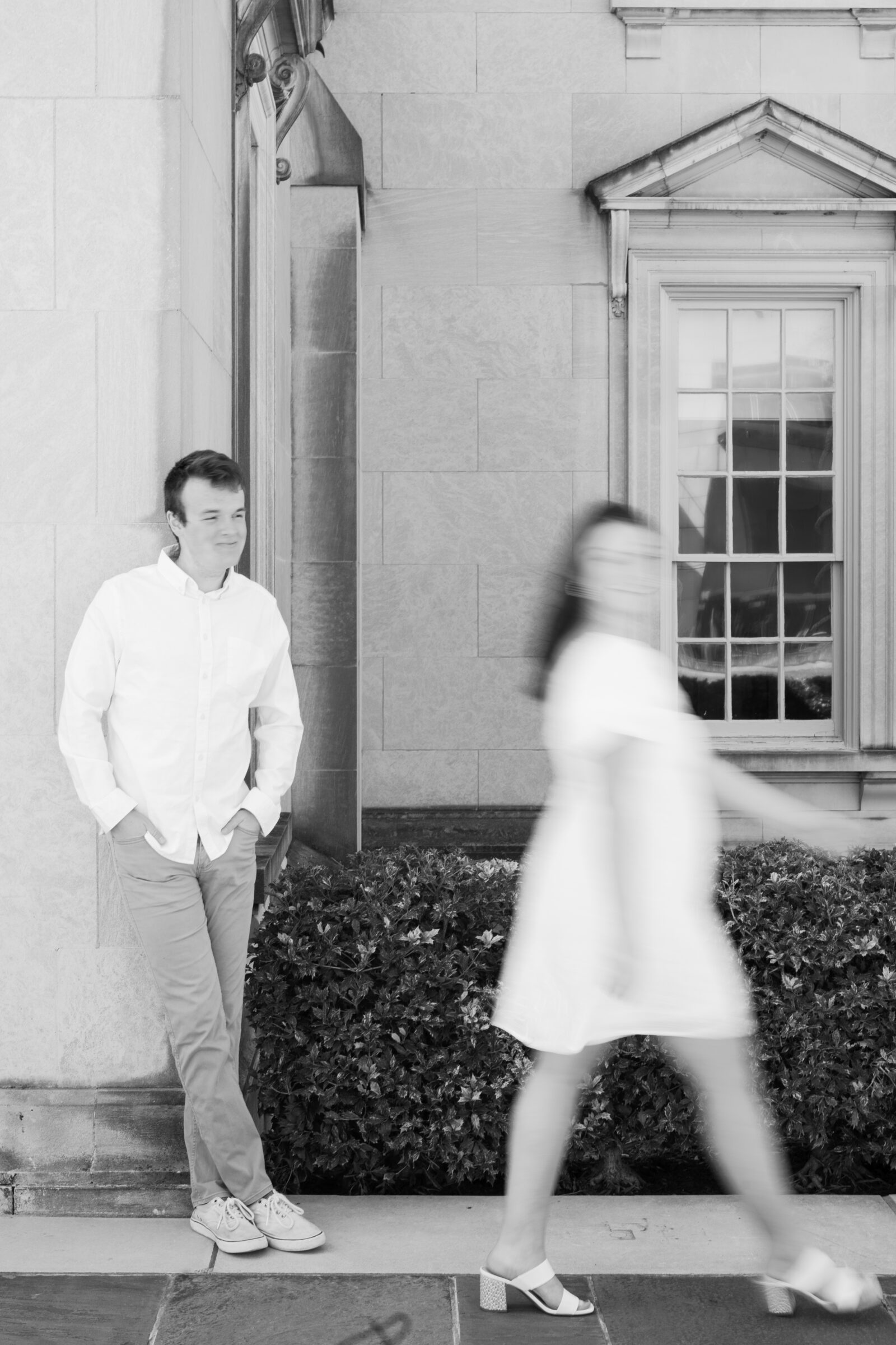 Engagement Session at the VMFA in Richmond VA | black and white image of a guy watching his fiancee walk blurrily past him