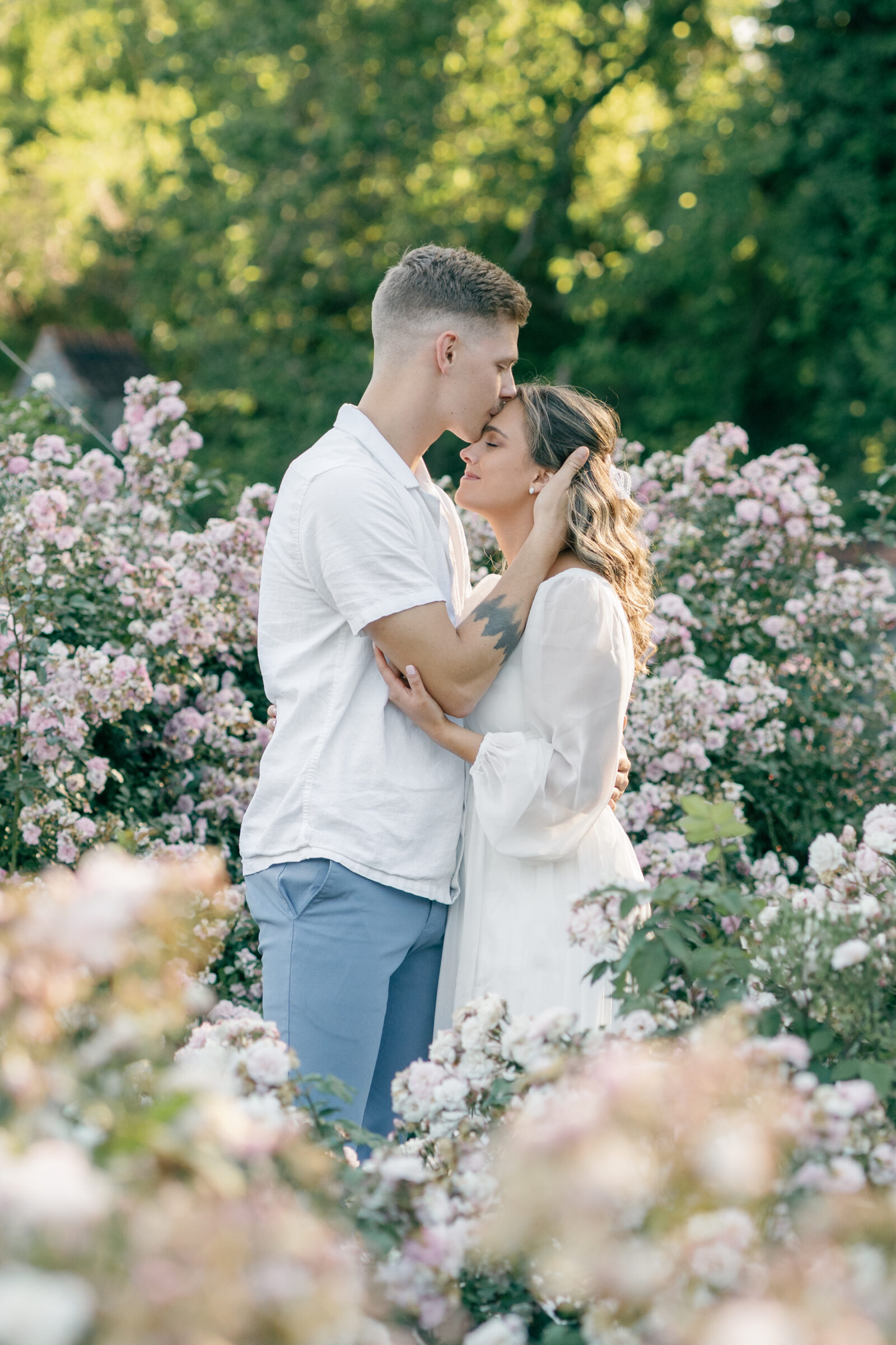 Engagement Photos at the Biltmore Estate Gardens | couple amidst the flowers - boy kisses girl's forehead