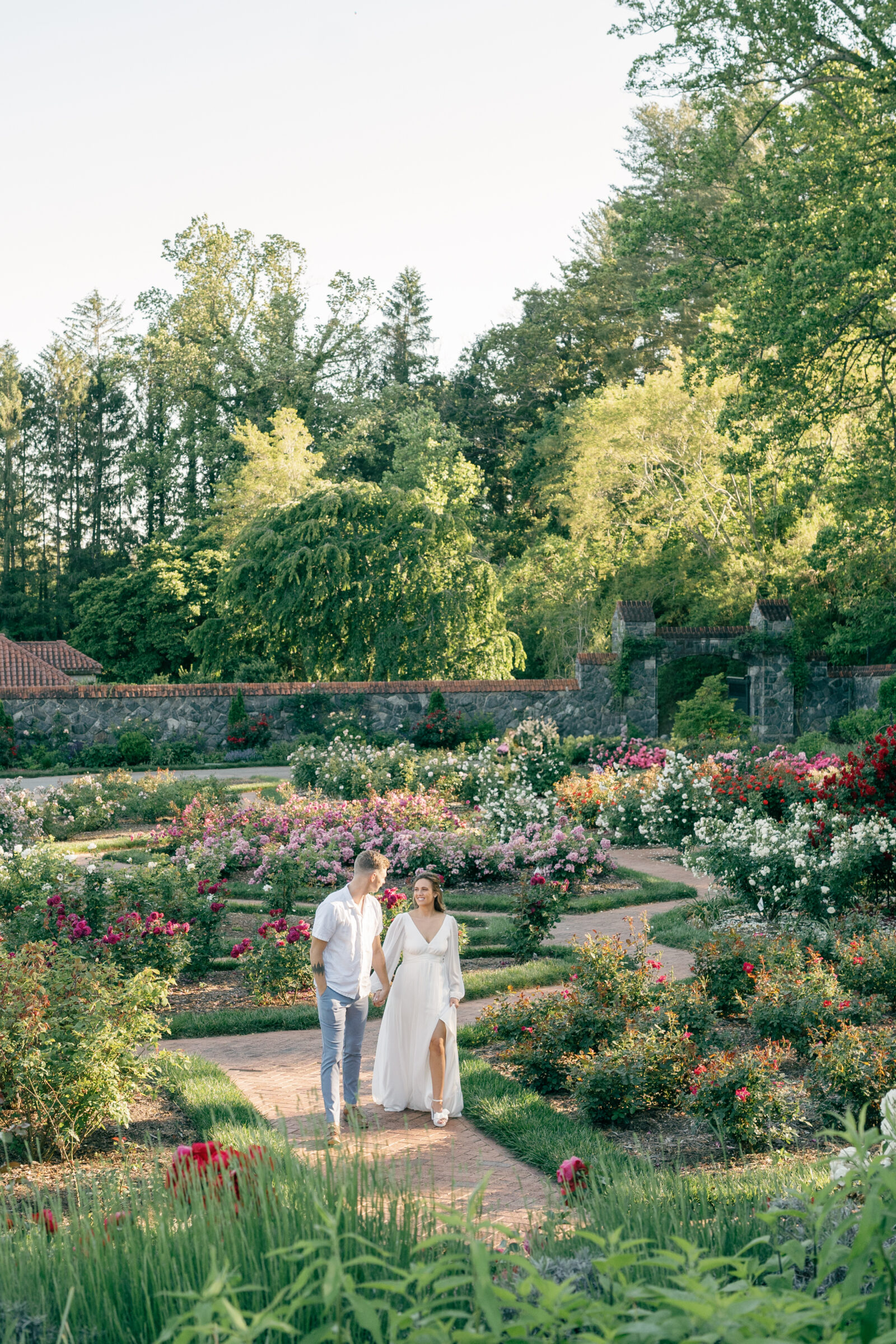 Engagement Photos at the Biltmore Estate Gardens | couple walk hand in hand through garden