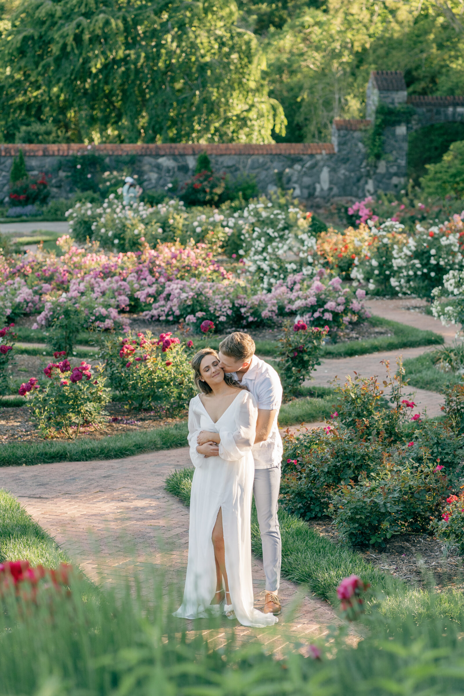 Engagement Photos at the Biltmore Estate Gardens | guy hugs girl from behind and kisses her cheek