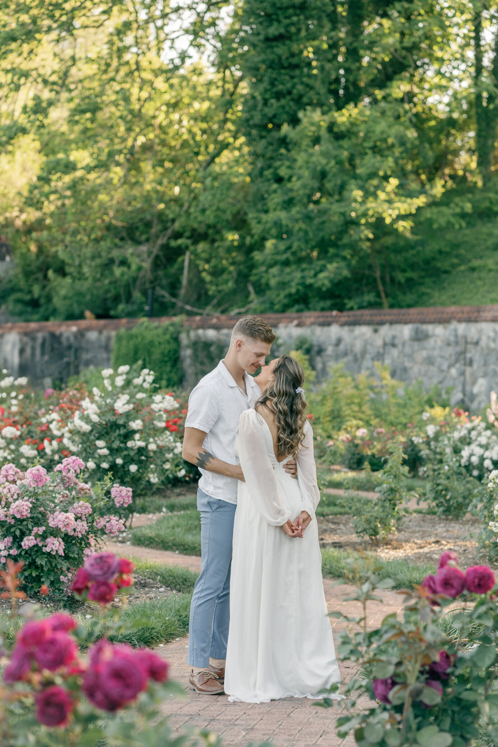 Engagement Photos at the Biltmore Estate Gardens | guy pulls girl into him for a kiss