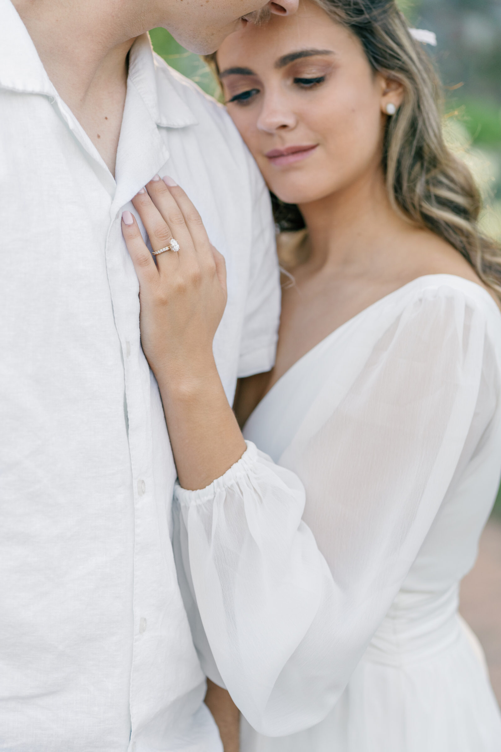 Engagement Photos at the Biltmore Estate Gardens | closeup image of engagement ring on girl's hand as she lays her head on guy's chest