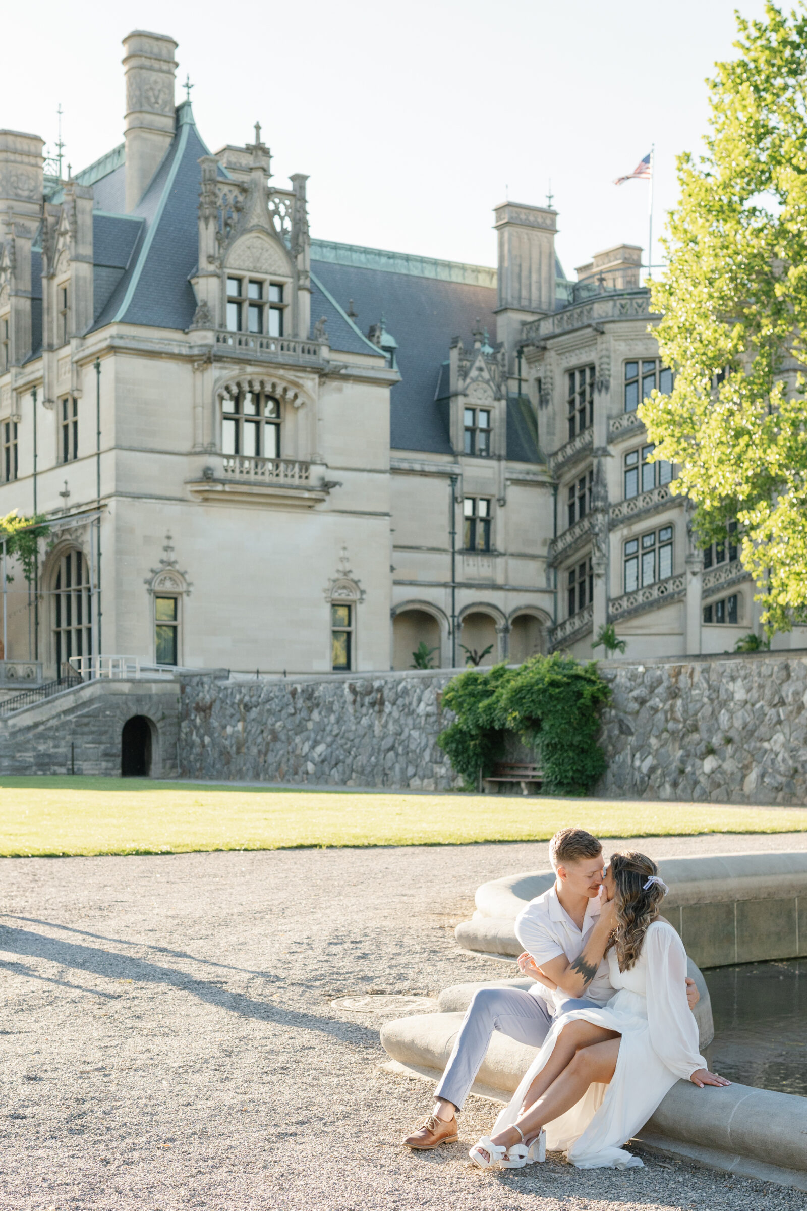 Engagement Photos at the Biltmore Estate | couple sit on edge of fountain