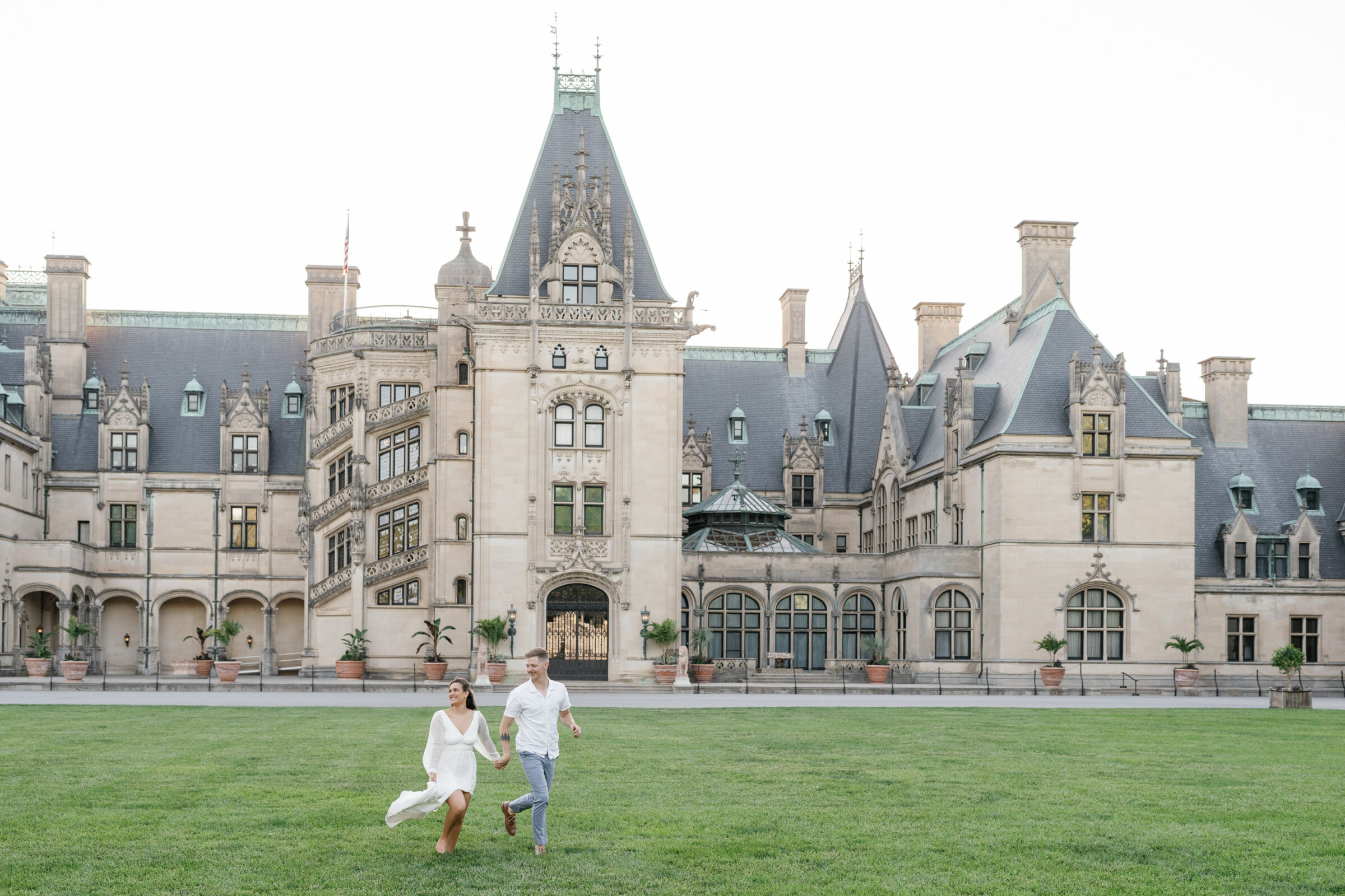 Engagement Photos at the Biltmore Estate House | couple run on front lawn of the Biltmore House