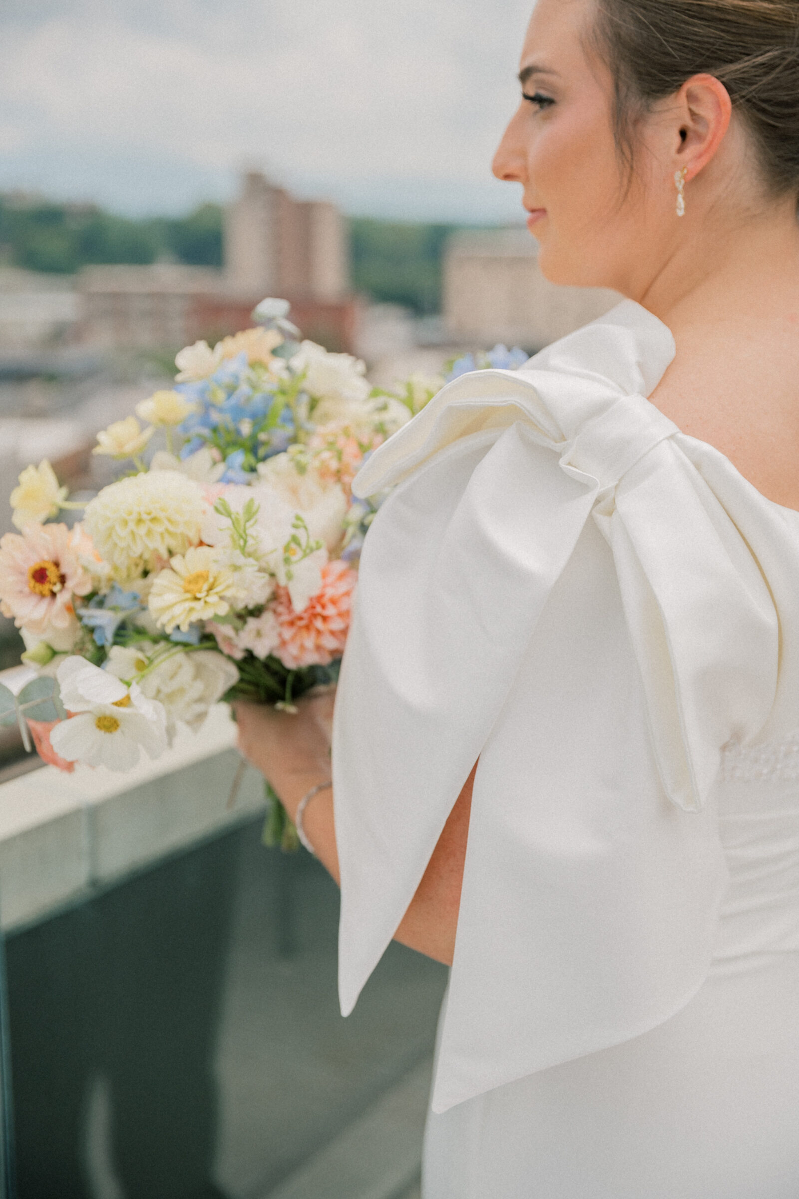 Bristol Hotel Wedding | bow detail on bride's dress with bridal bouquet in the background