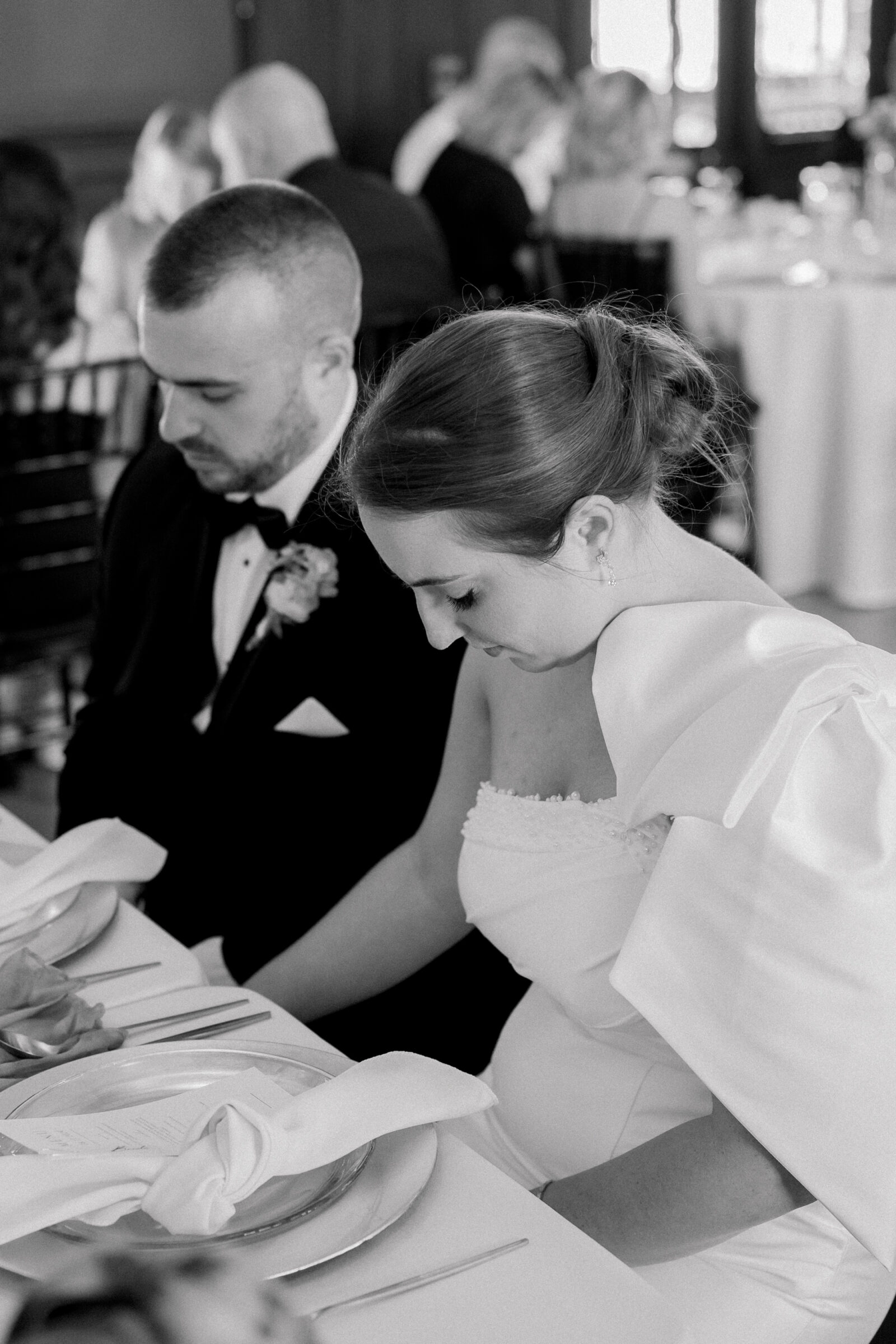 Bristol Train Station Wedding | bride and groom lower head in prayer before dinner