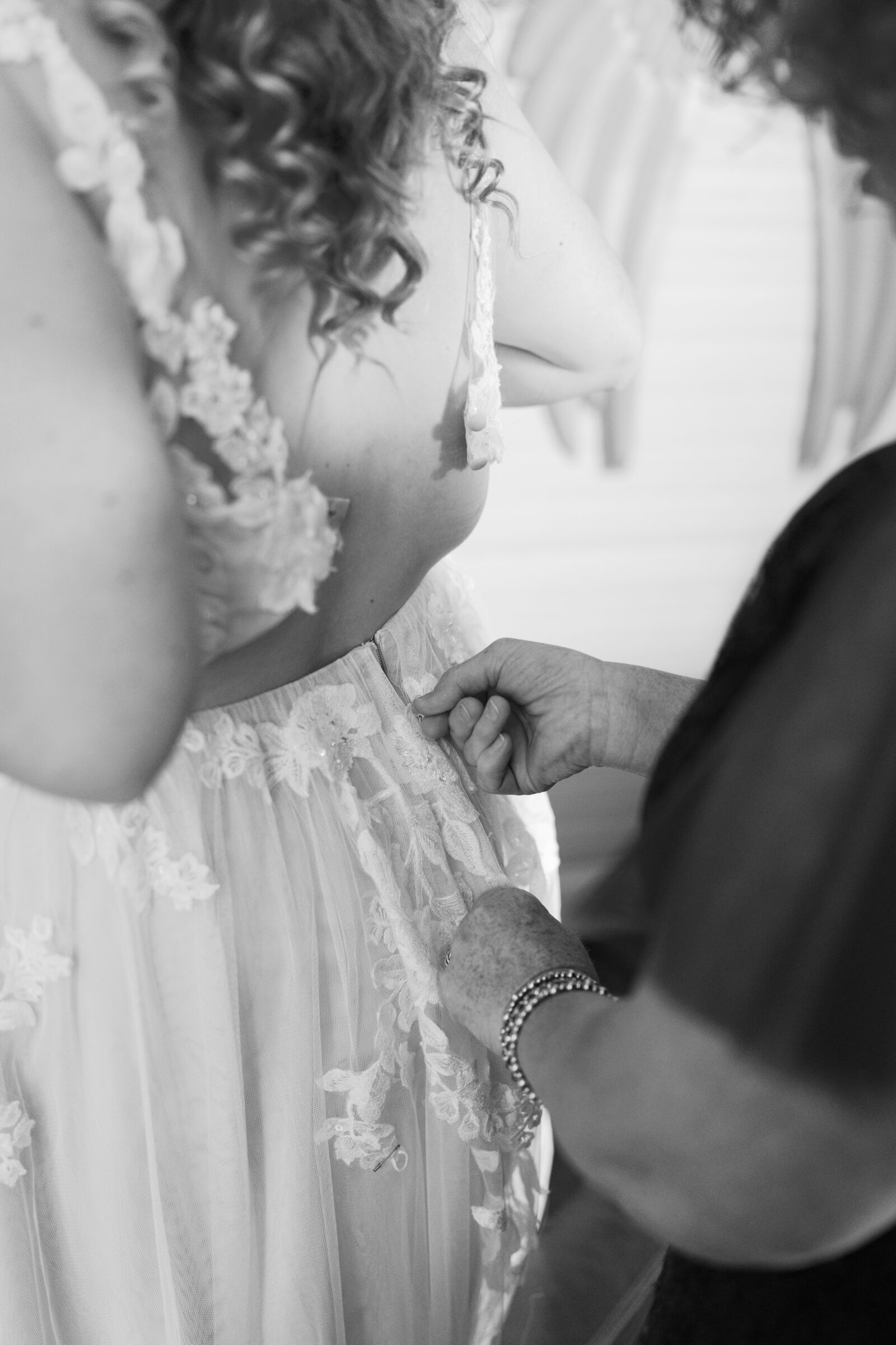 Full Bloom Farm Wedding | black and white image of bride getting zipped into her wedding dress