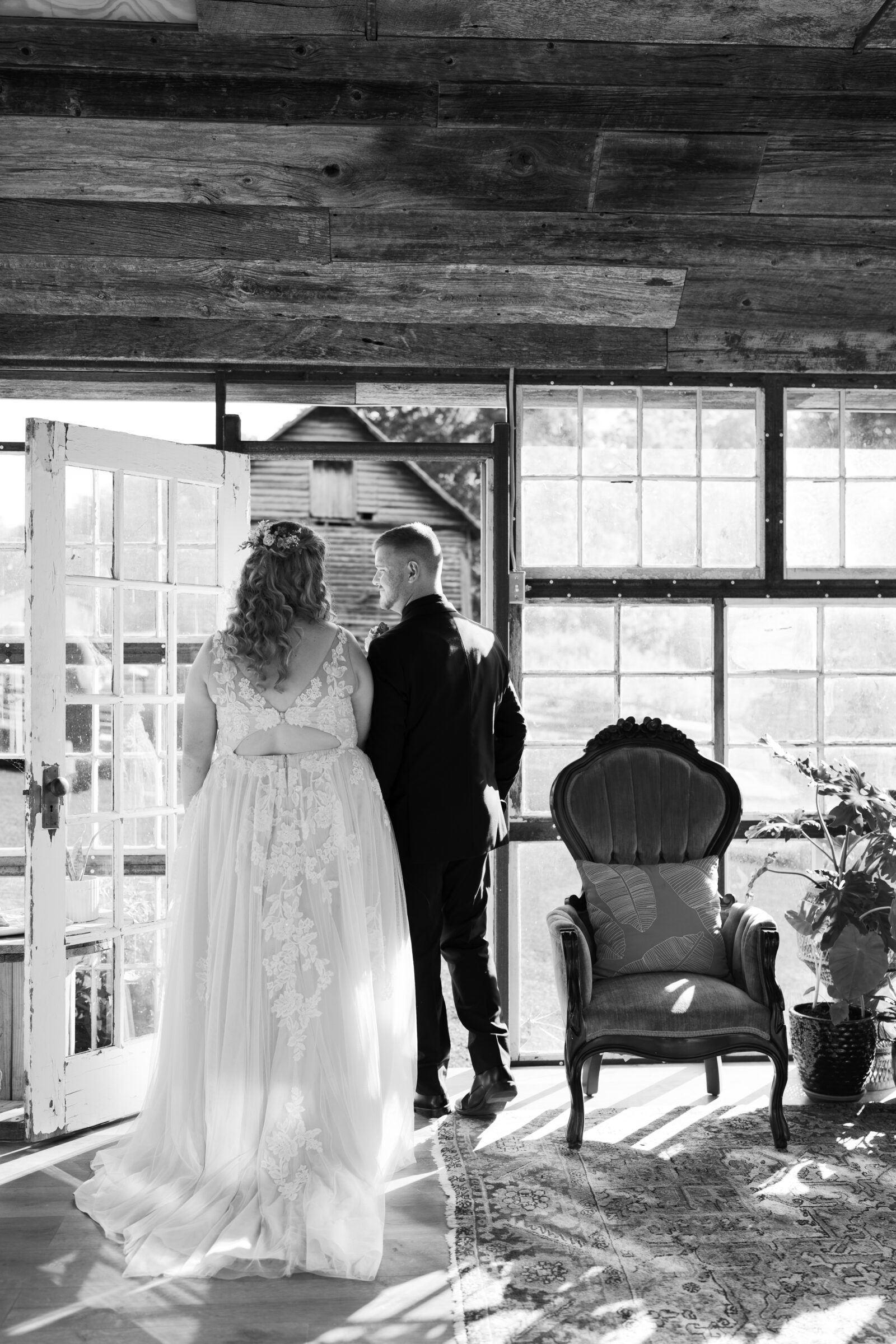 Abingdon Wedding Photographer | black and white image of bride and groom walking out of a greenhouse, away from the camera