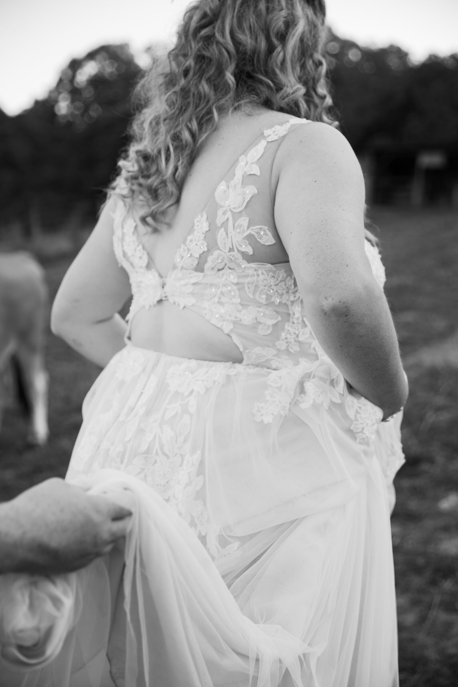 Abingdon VA Wedding Photographer | black and white closeup image of groom holding bride's dress as they walk
