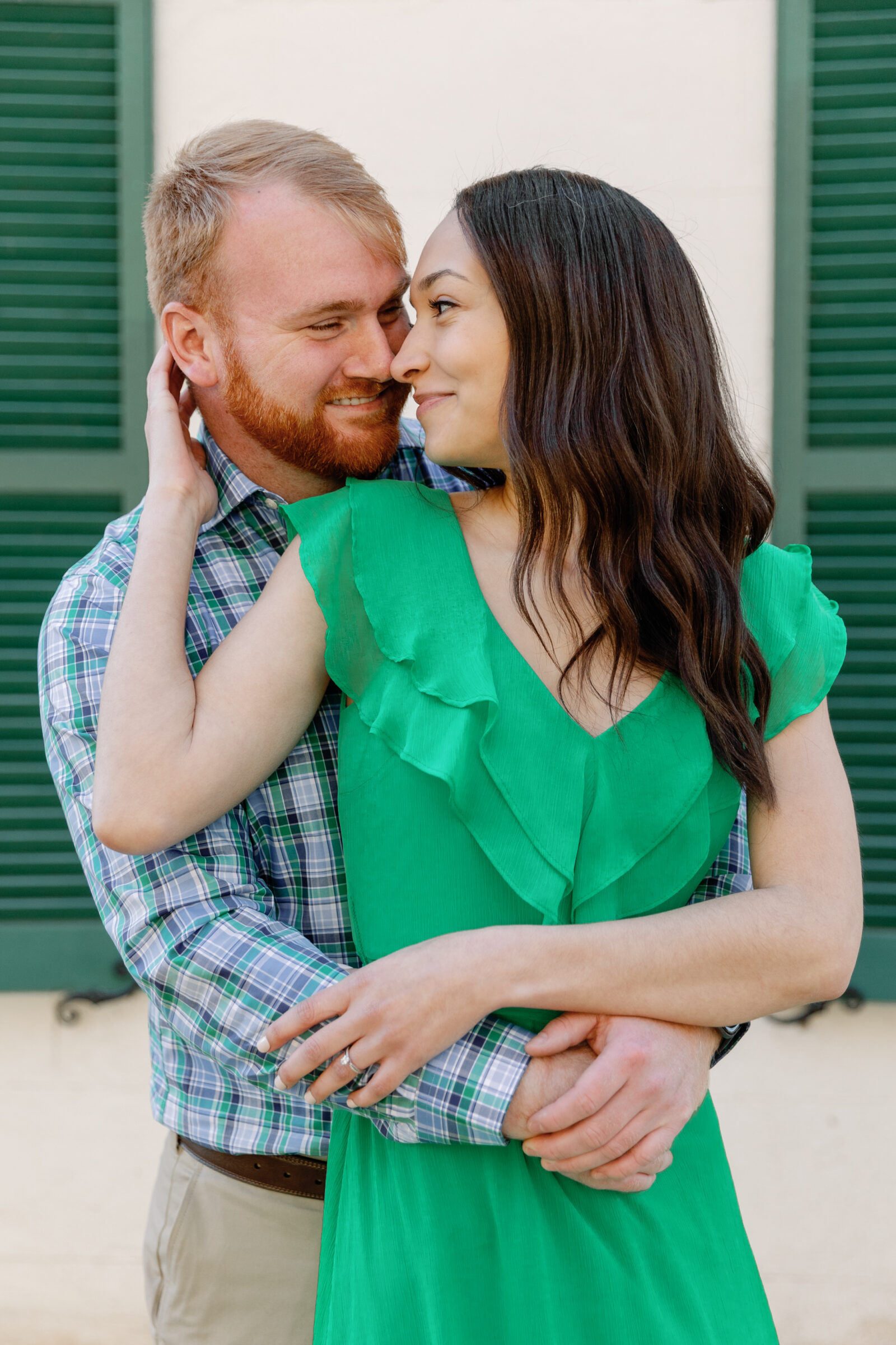 Engagement Session at Great Falls Park in Maryland | girl in green dress is nose to nose with her fiance while he hugs her