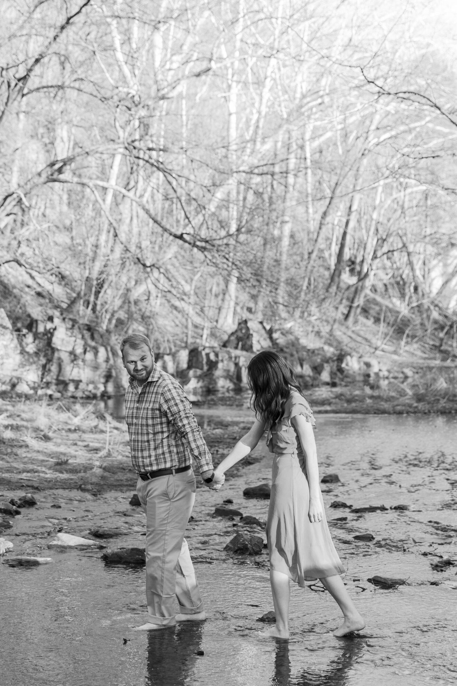 Engagement Session at Great Falls Park in Maryland | black and white image of couple walking in a river