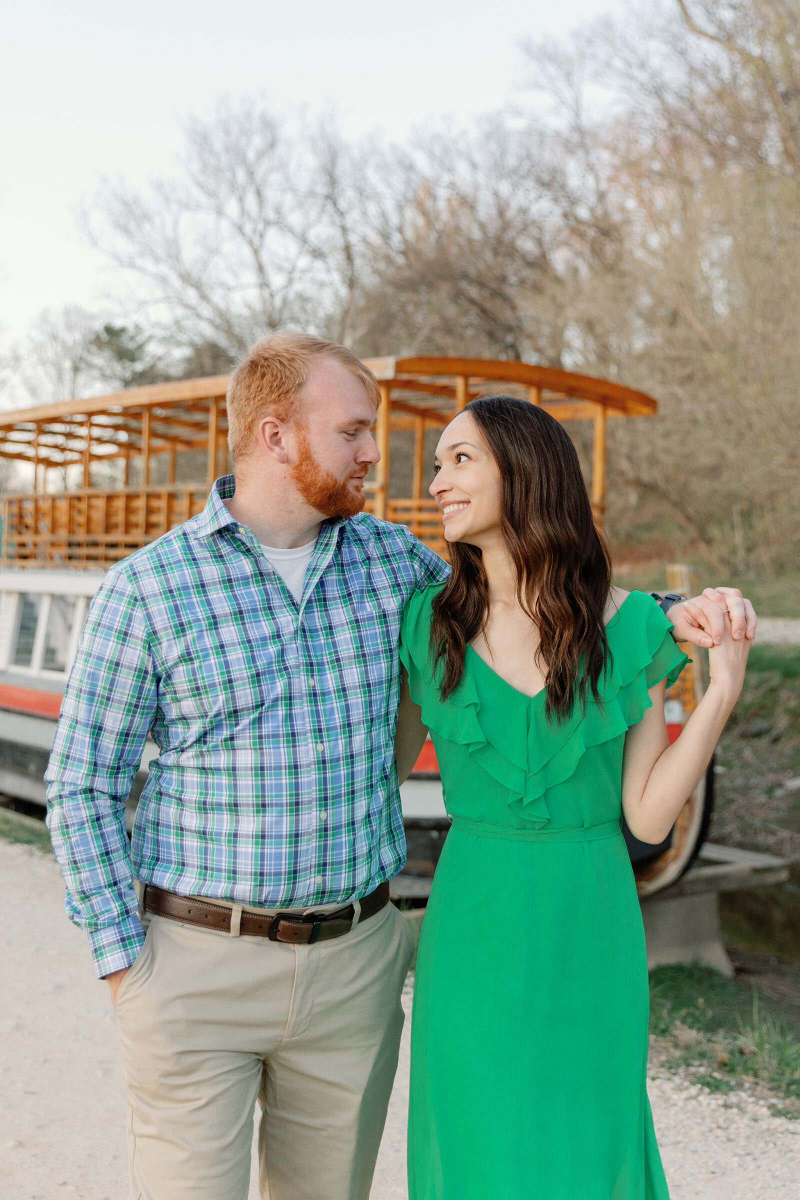 Engagement Session at Great Falls Park in Maryland | couple walk arm in arm in front of a boat