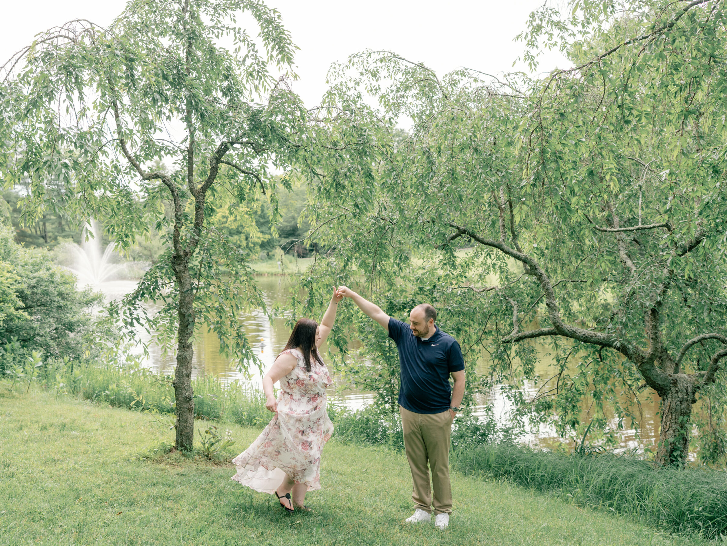 Meadowlark Botanical Gardens Engagement Session | groom spins his bride in front of a pond at Meadowlark Botanical Gardens in Northern Virginia