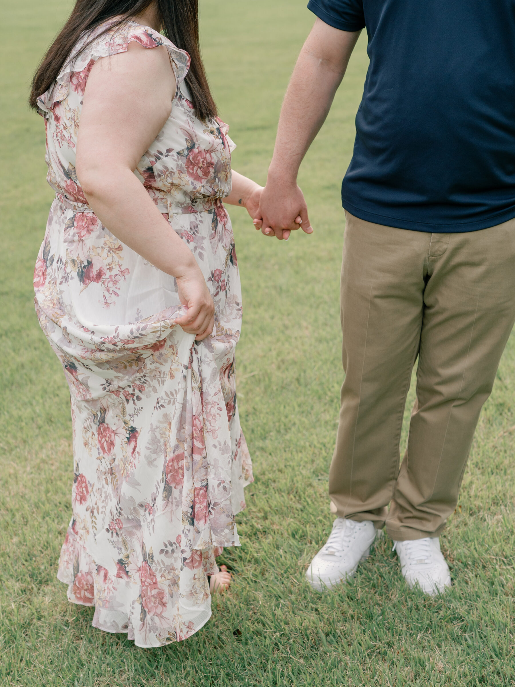 Meadowlark Botanical Gardens Engagement Photos | girl in floral dress holds her dress while holding hands with her groom-to-be