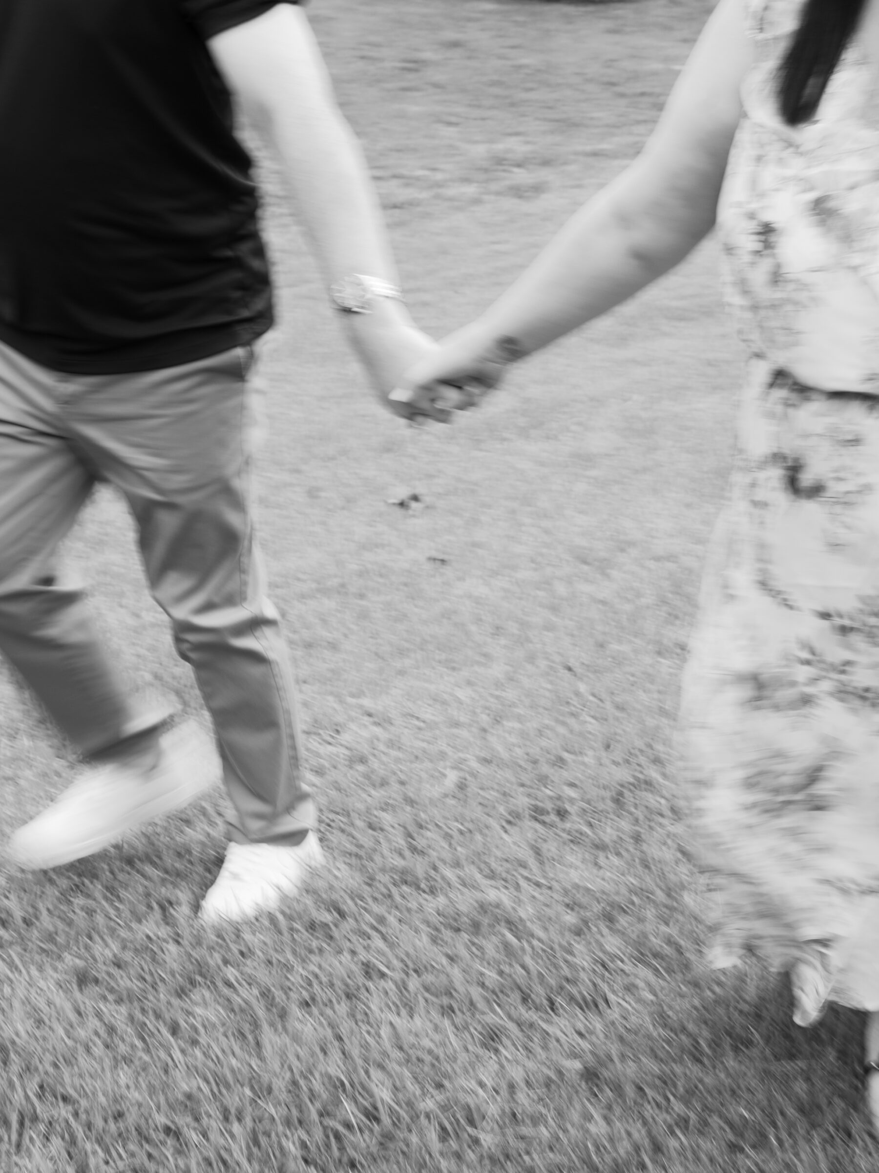 Meadowlark Botanical Gardens Engagement Photos | blurry black and white image of couple holding hands and walking at Meadowlark Botanical Gardens in Vienna, VA