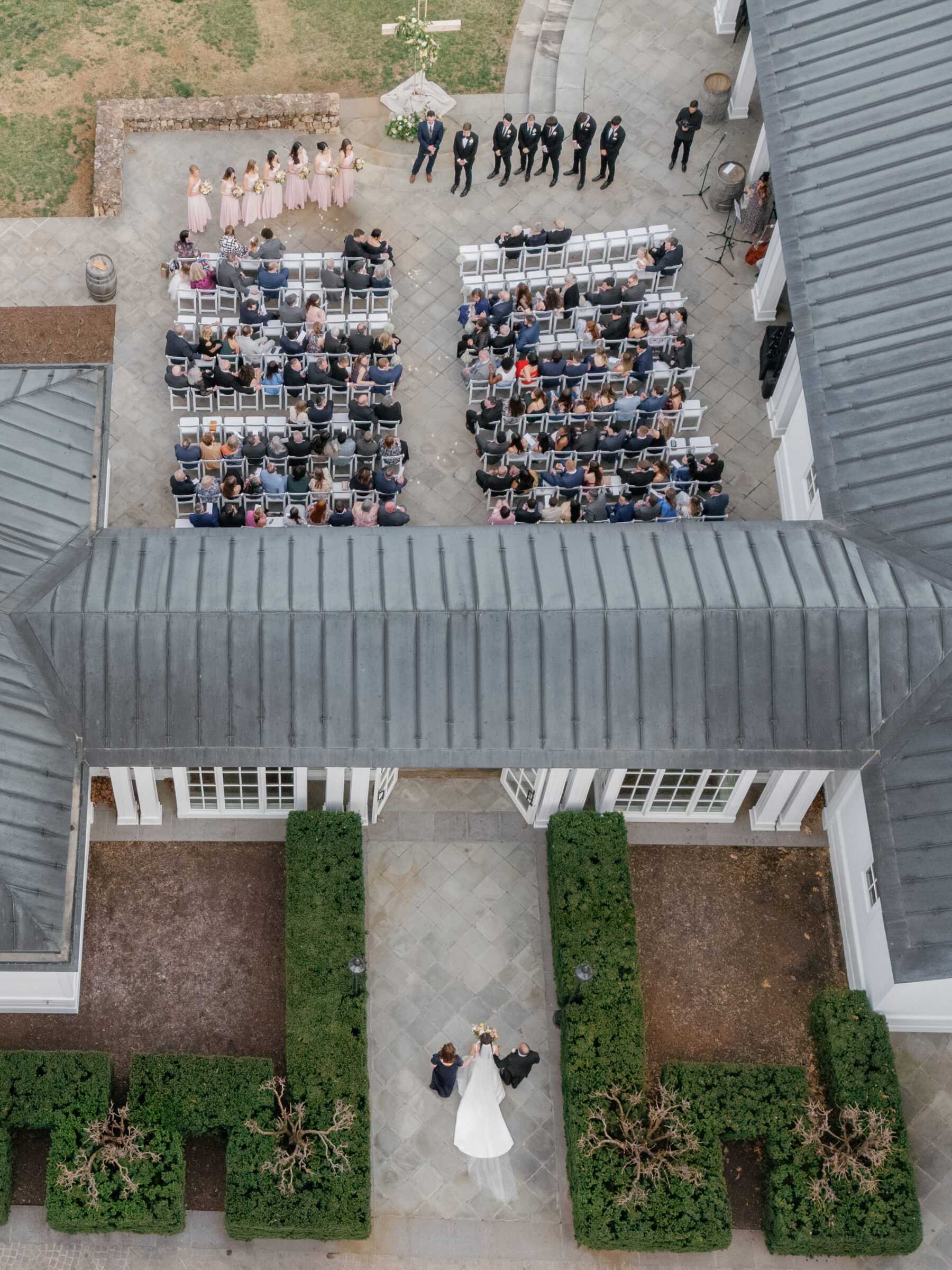 Trump Winery Grand Hall in Charlottesville, VA | a image taken on drone of a bride walking down the aisle to her groom during a wedding ceremony