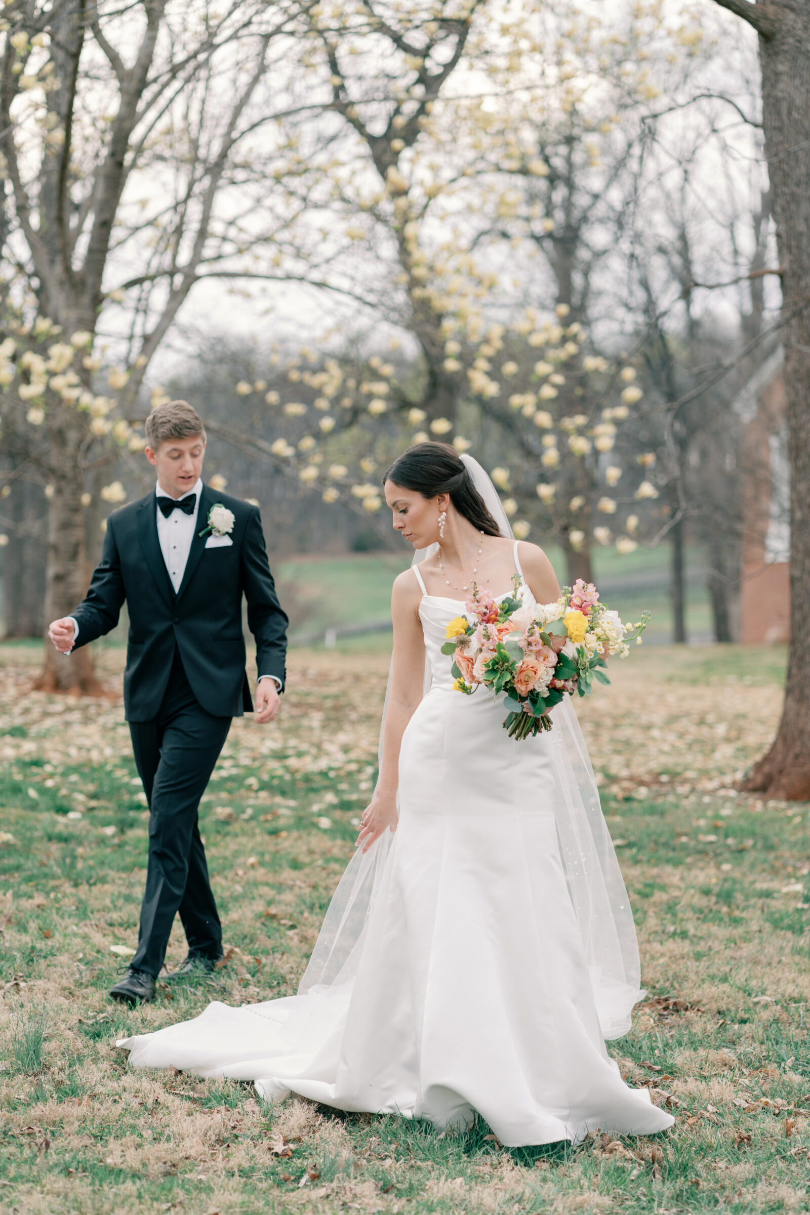 Trump Winery Grand Hall in Charlottesville, VA | bride reaches for her veil as she walks ahead of her groom